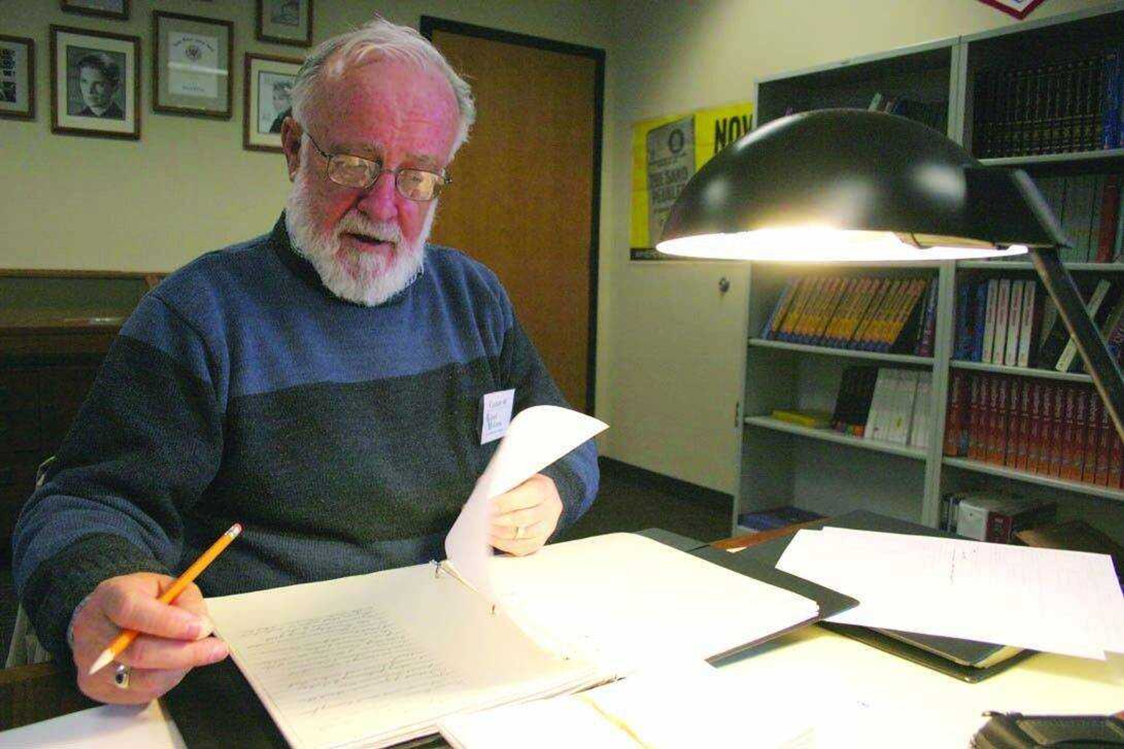 Dr. Dennis Noble studies some of the archives in the McKenna collection at Richard McKenna Charter High School. <i><small>Photo by Brian S. Orban</i></small>