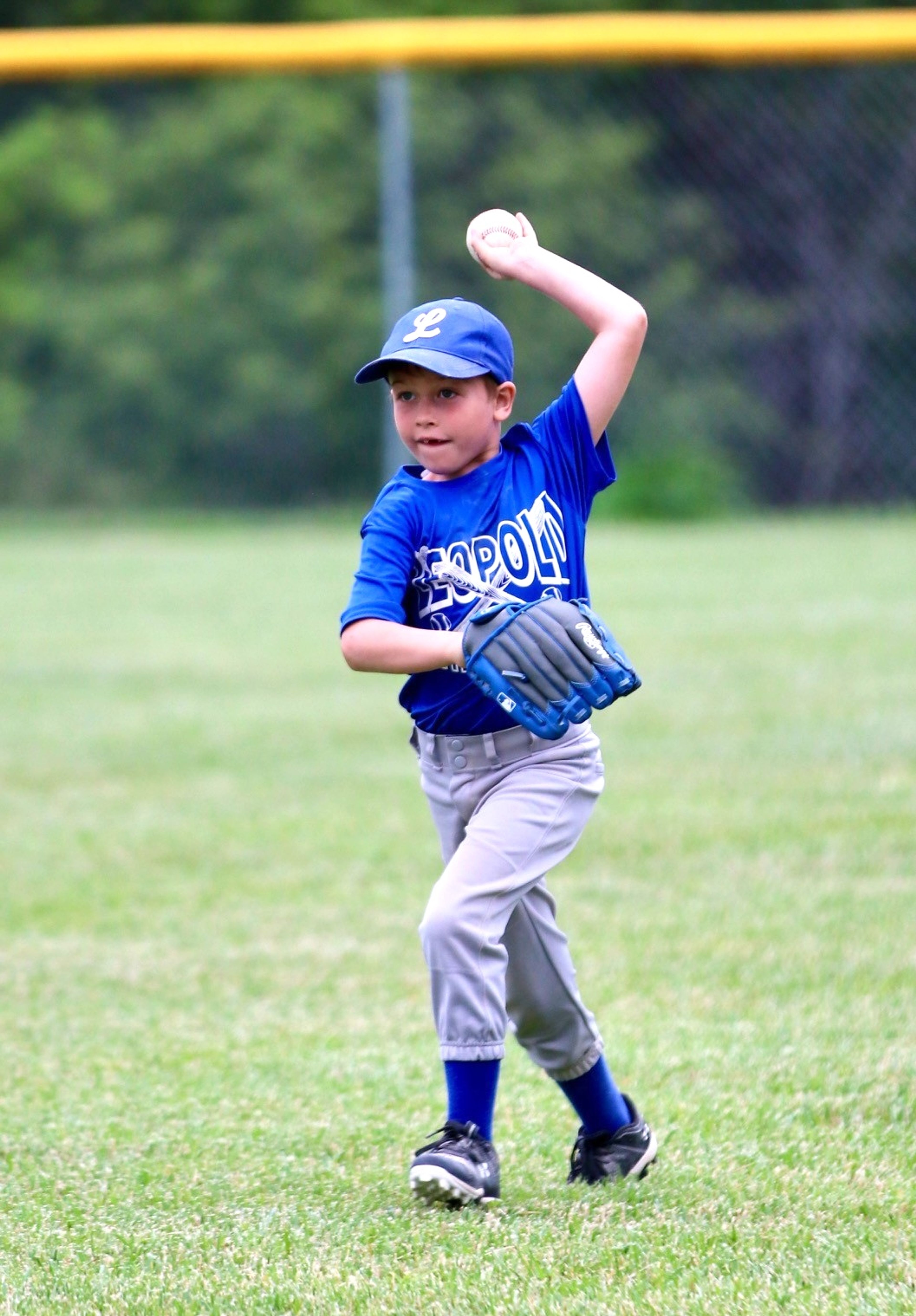 
8U baseball player Ben Francis throws a ball to the infield.