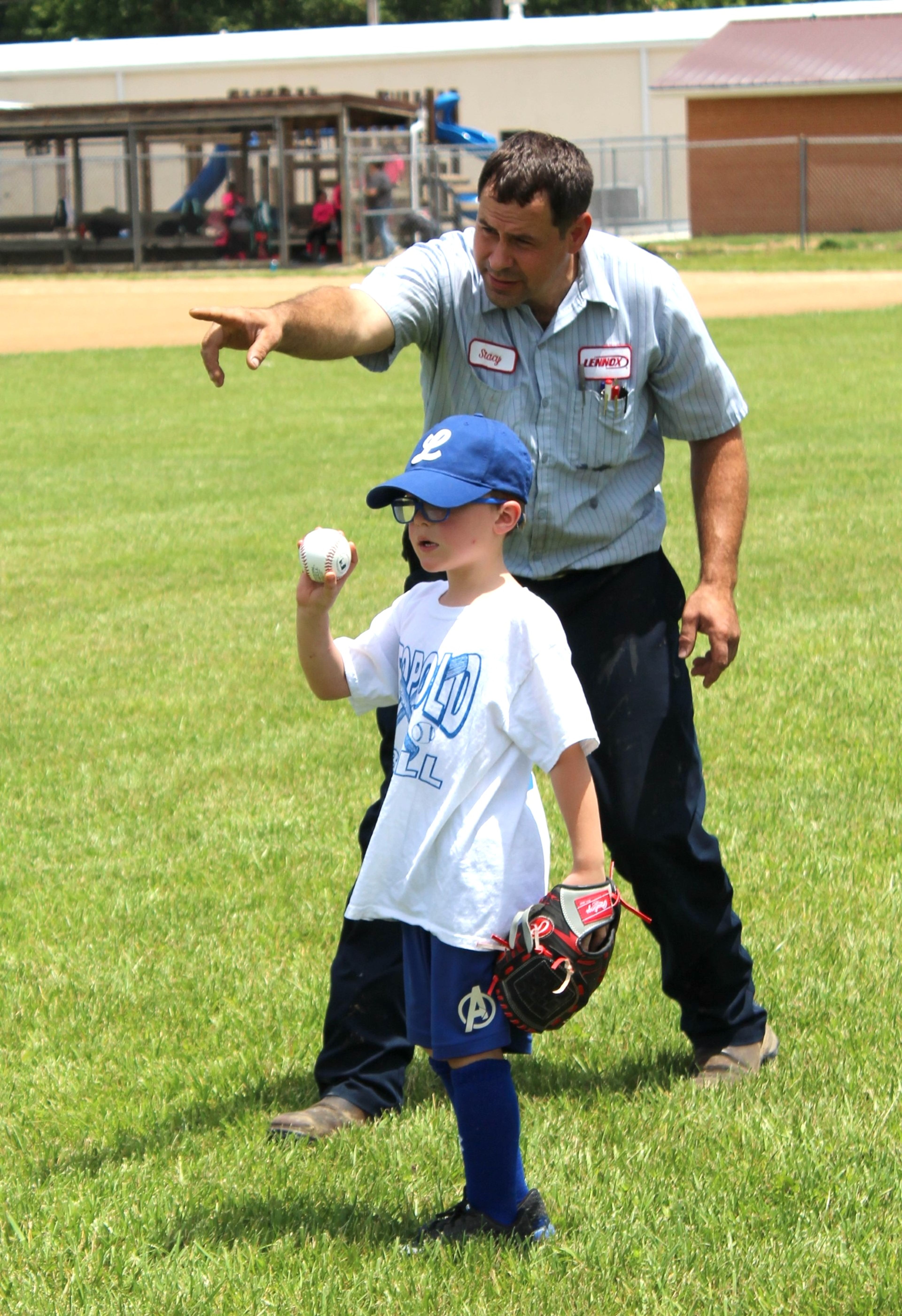 
Robert Deck throws a ball to the infield during the T-ball game.  Stacey Peters provides direction and helps him locate his target.