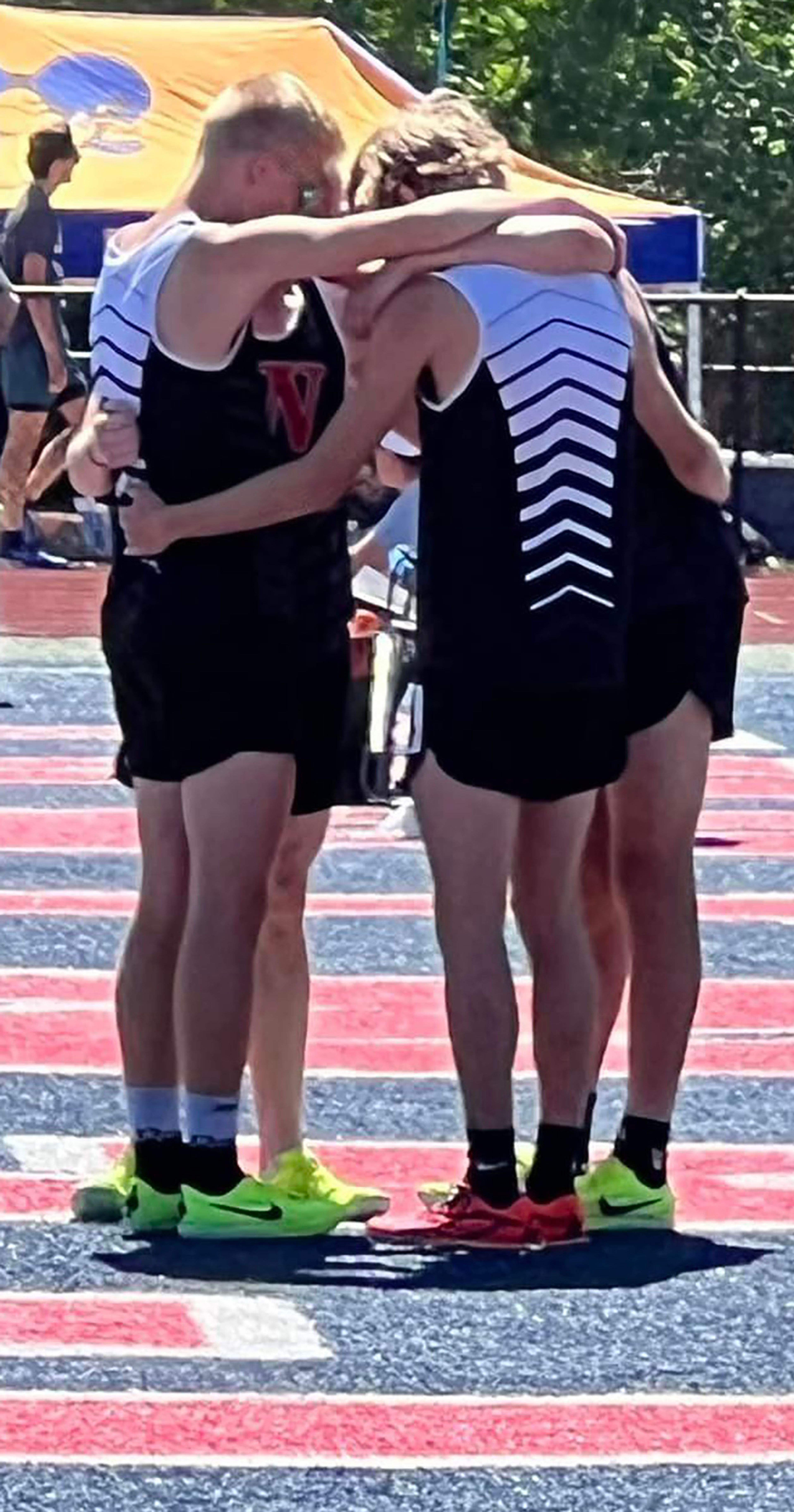 The boys 4x800 relay members circle up for their pre-race prayer.