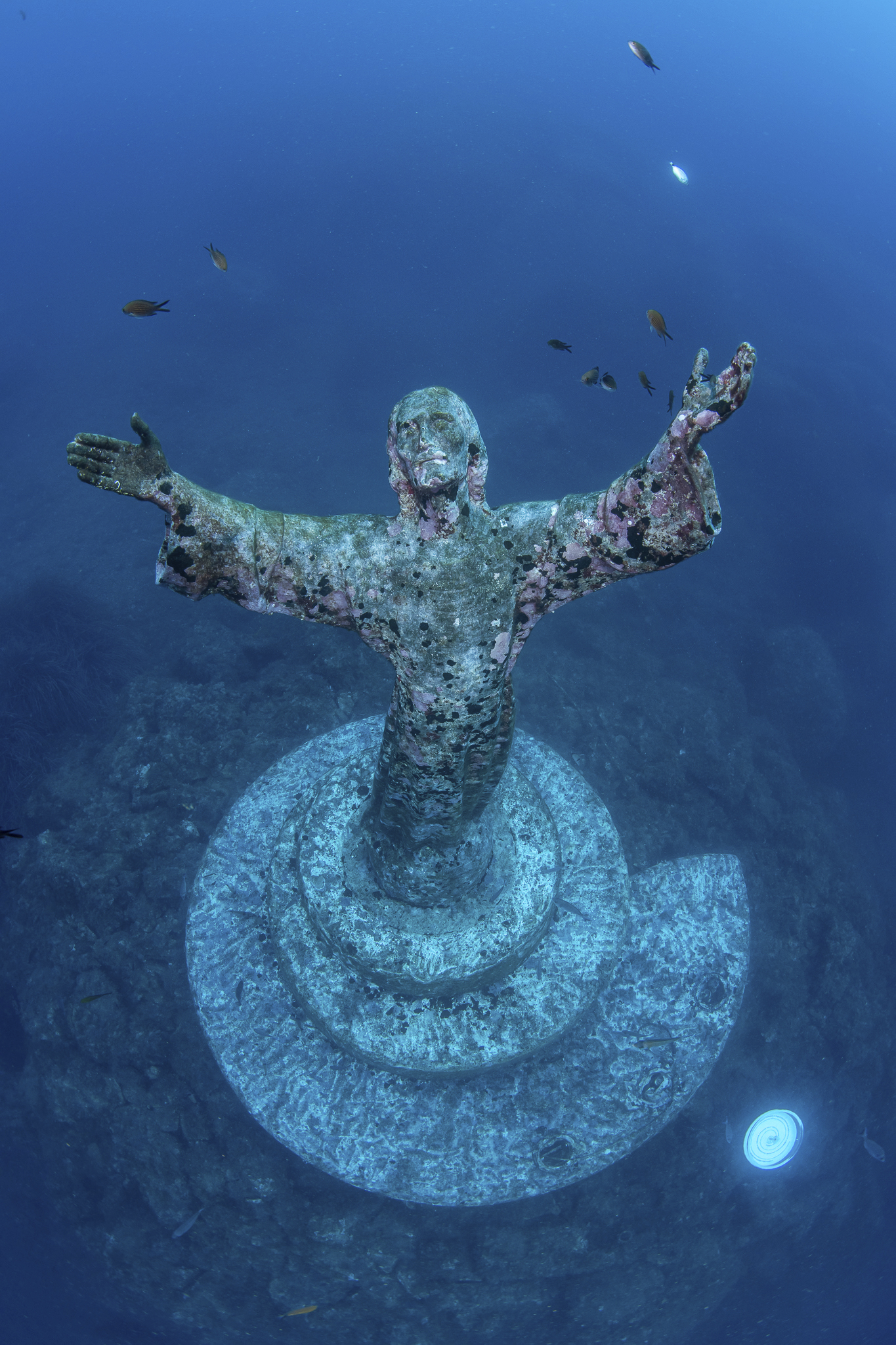Italian divers water-blast the popular underwater statue of