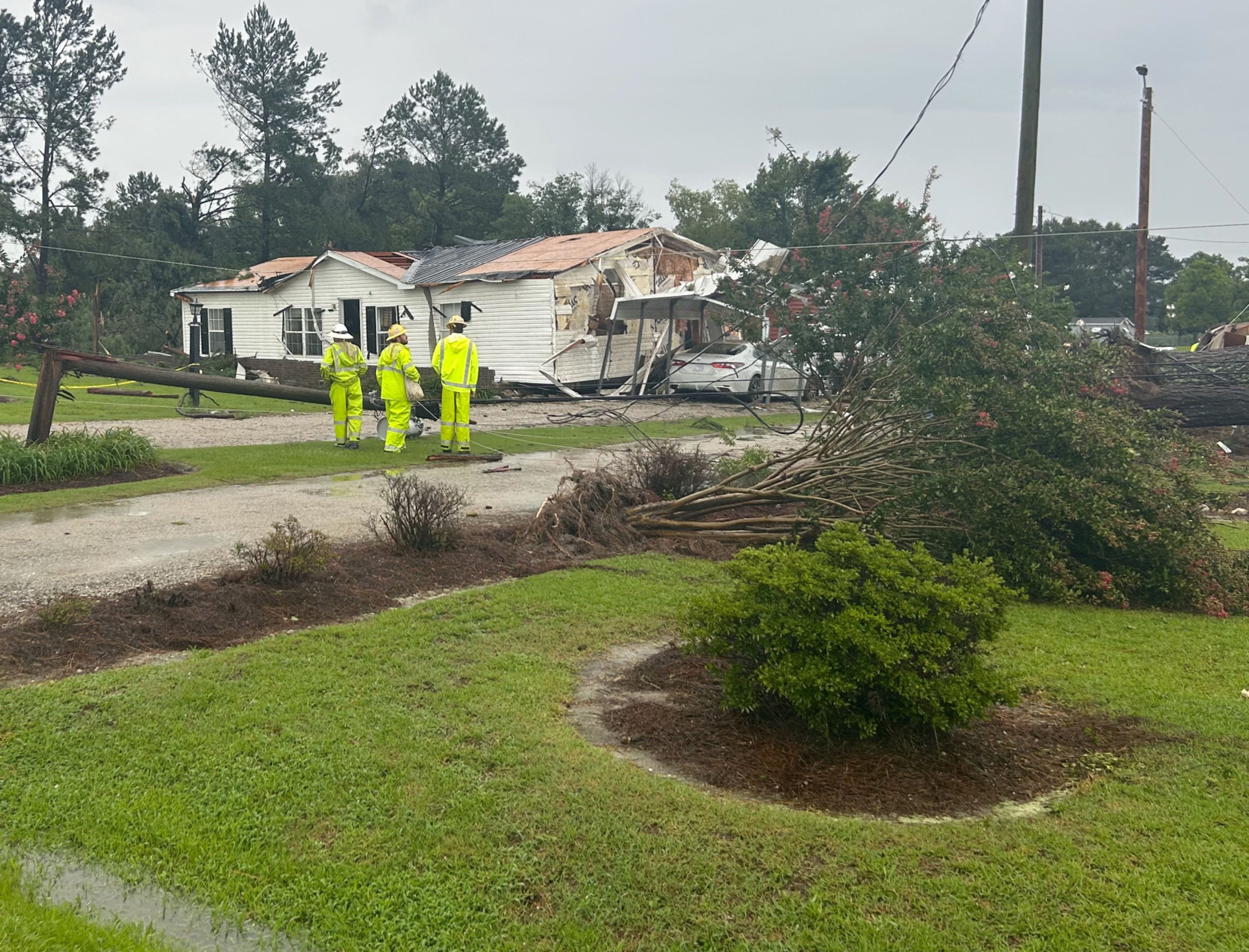 Wilson Energy employees survey storm damage on Lloyd Road near Lucama. A Thursday tornado damaged homes and disrupted electric service in the area. Christopher Long | Times