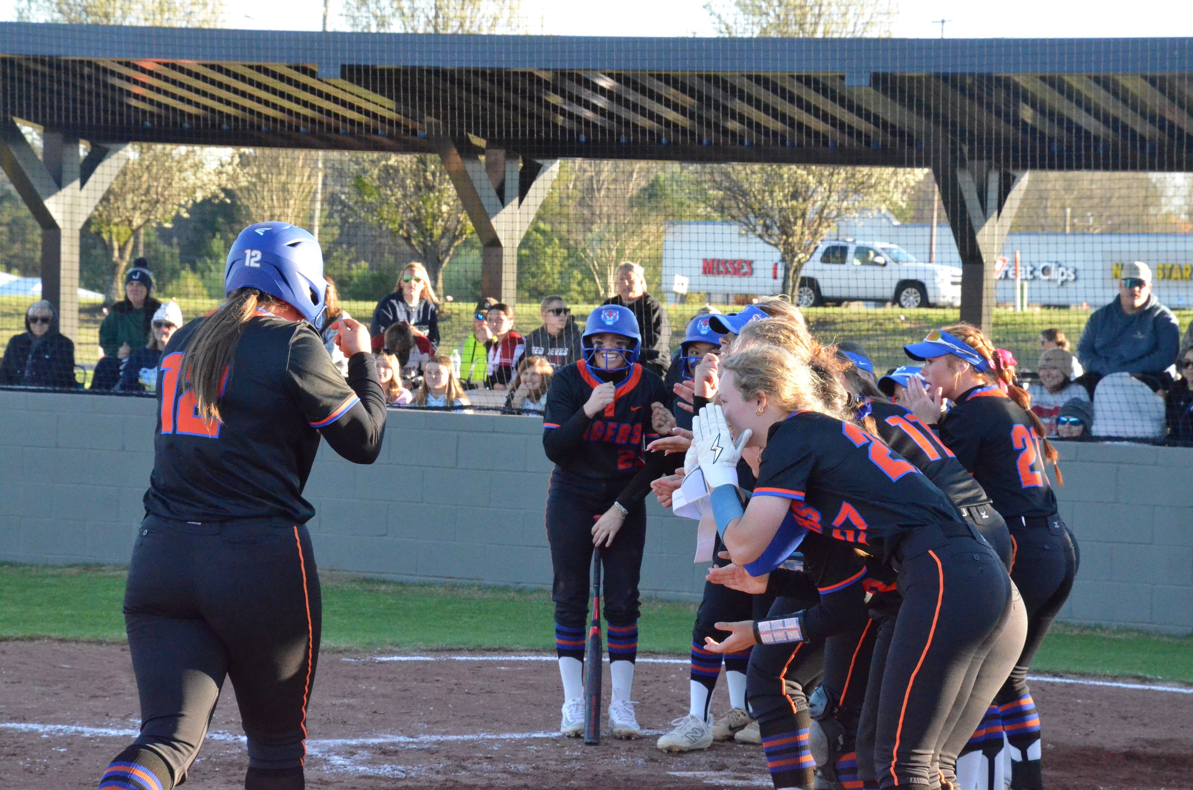 Chilton County High School’s Mallie Harrison greeted by her team after hitting a two-run home run.
