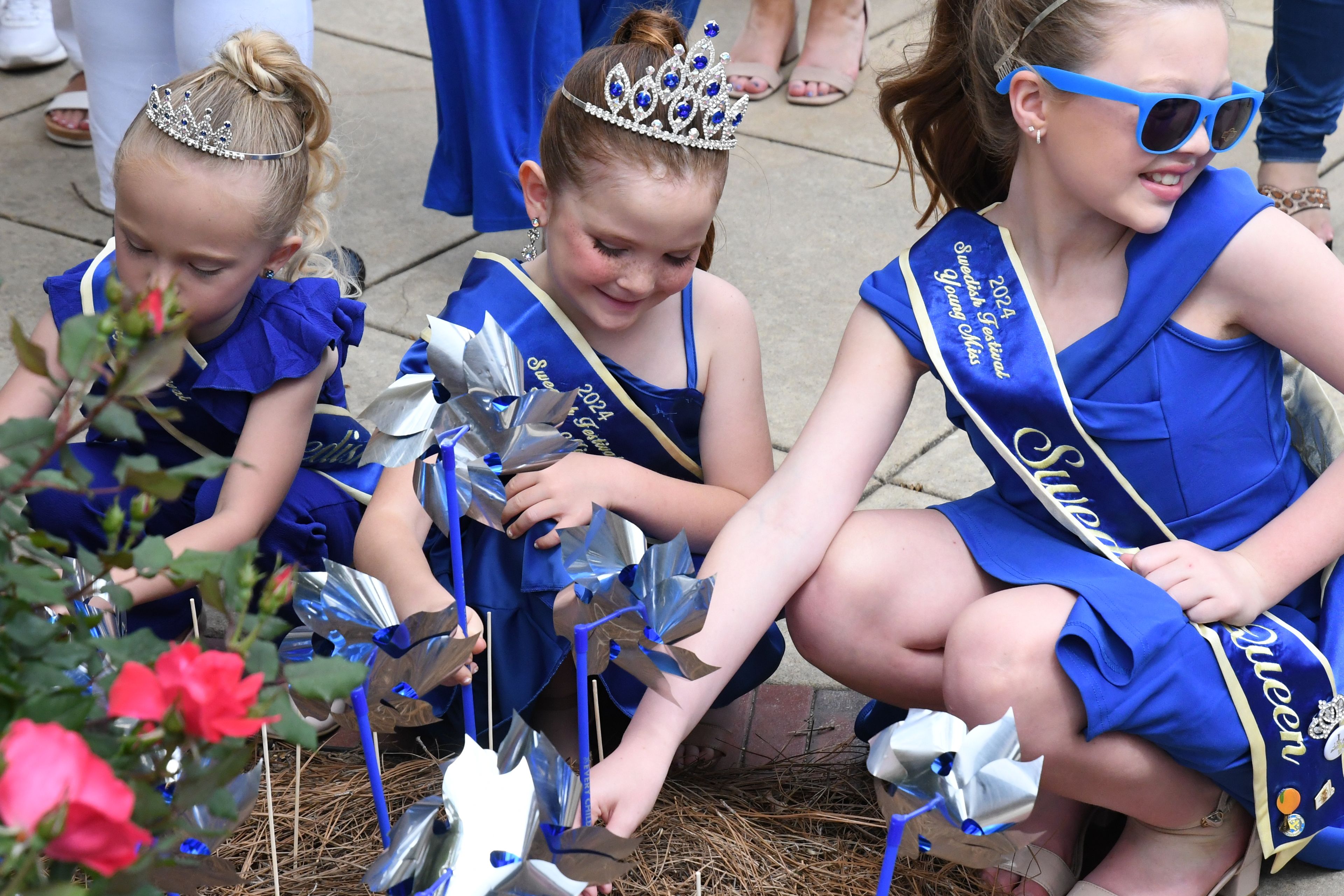 Young queens plant pinwheels at Clanton Corner Park during Butterfly Bridge Children’s Advocacy Center’s Pinwheel Parade.