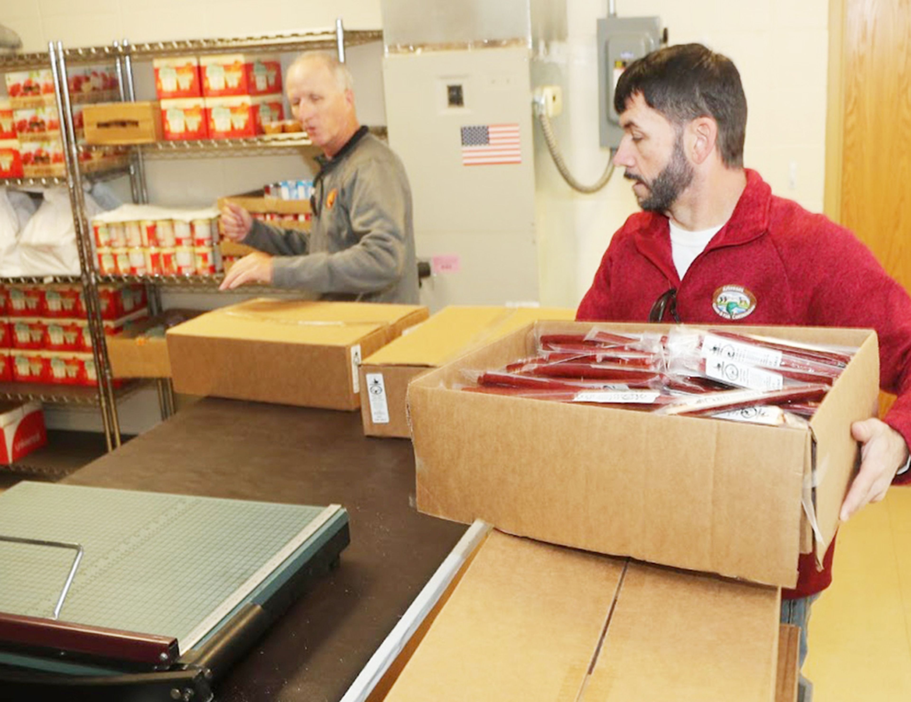 Brown (right) helps Arkansas Hunters Feeding the Hungry Director Ronnie Ritter with its highly successful snack stick program, delivering much needed protein to schools for backpack programs. AGFC photo by Mike Wintroath.