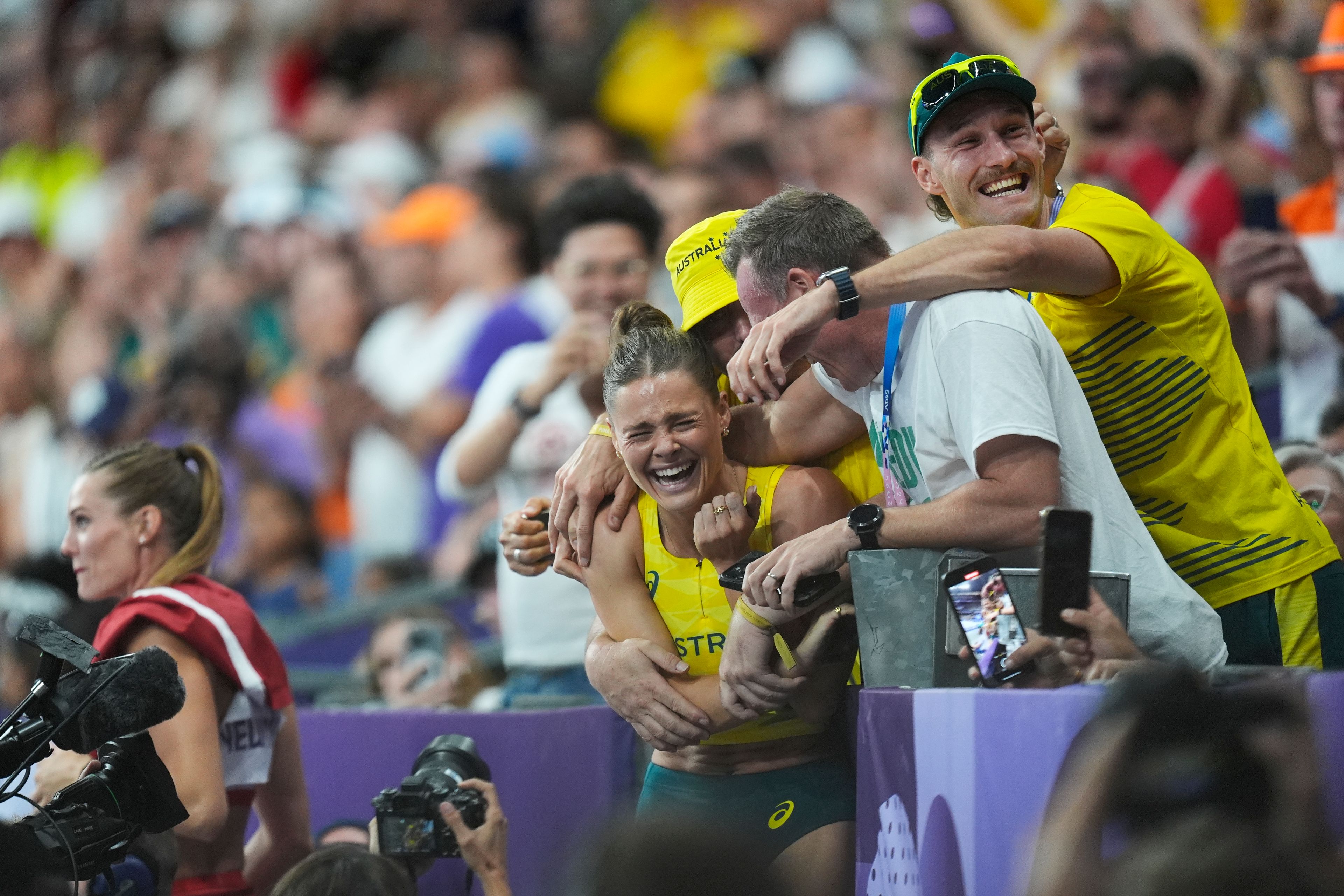 Nina Kennedy, of Australia, center, celebrates after winning the women's pole vault final at the 2024 Summer Olympics, Wednesday, Aug. 7, 2024, in Saint-Denis, France. (AP Photo/Rebecca Blackwell)