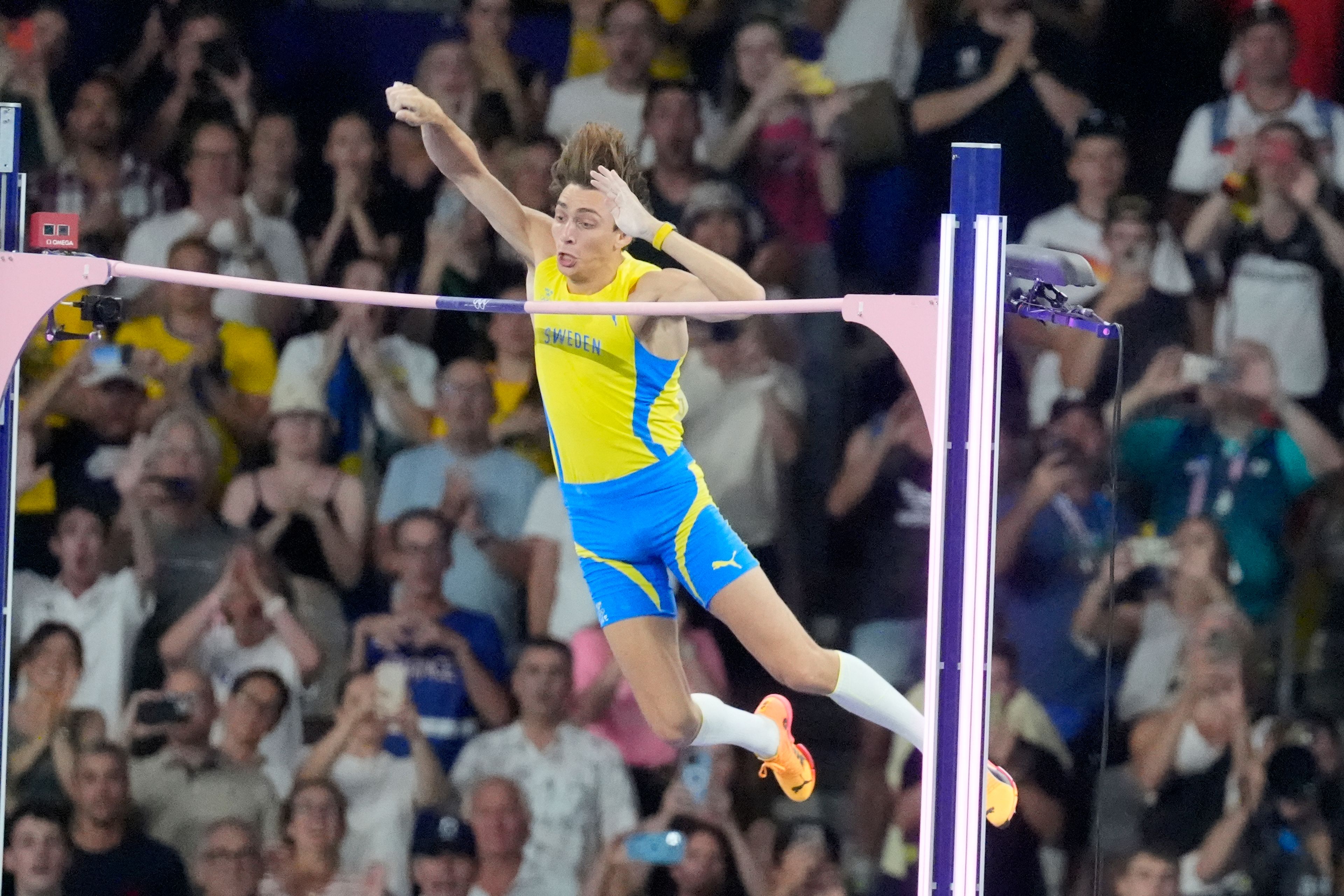 Armand Duplantis, of Sweden, clears the bar at 6.25 to set a new world record during the men's pole vault final at the 2024 Summer Olympics, Monday, Aug. 5, 2024, in Saint-Denis, France. (AP Photo/Martin Meissner)