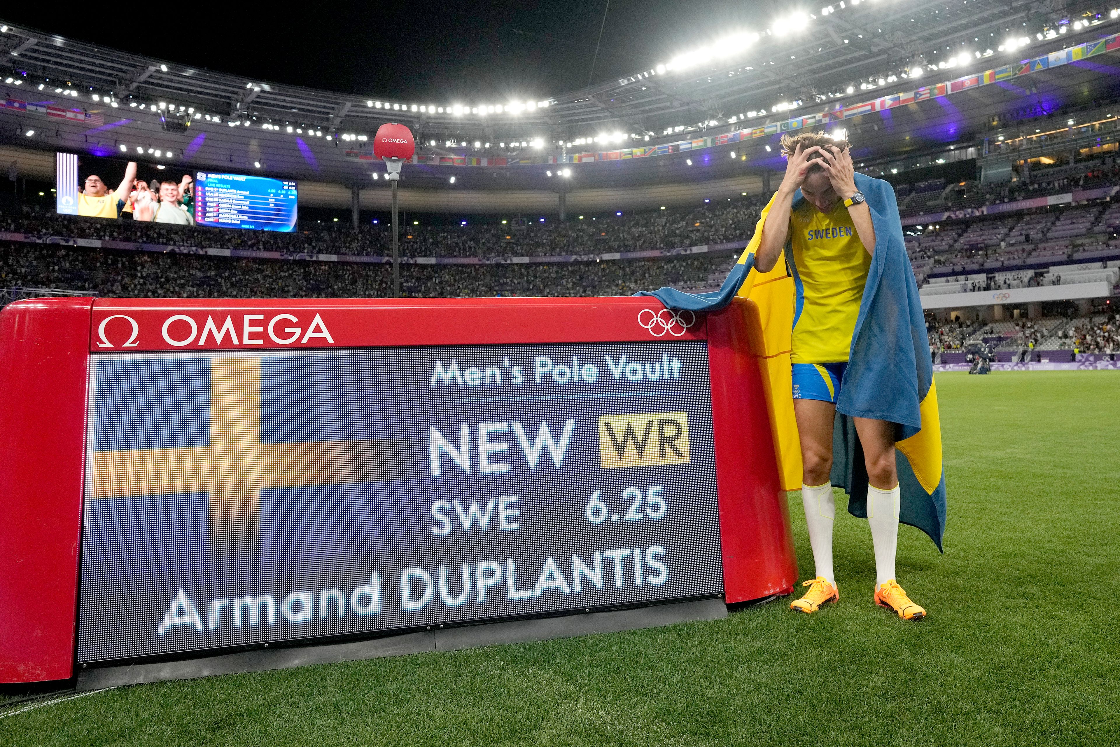 Armand Duplantis, of Sweden, reacts after setting a new world record in the men's pole vault final at the 2024 Summer Olympics, Monday, Aug. 5, 2024, in Saint-Denis, France. (AP Photo/Bernat Armangue)