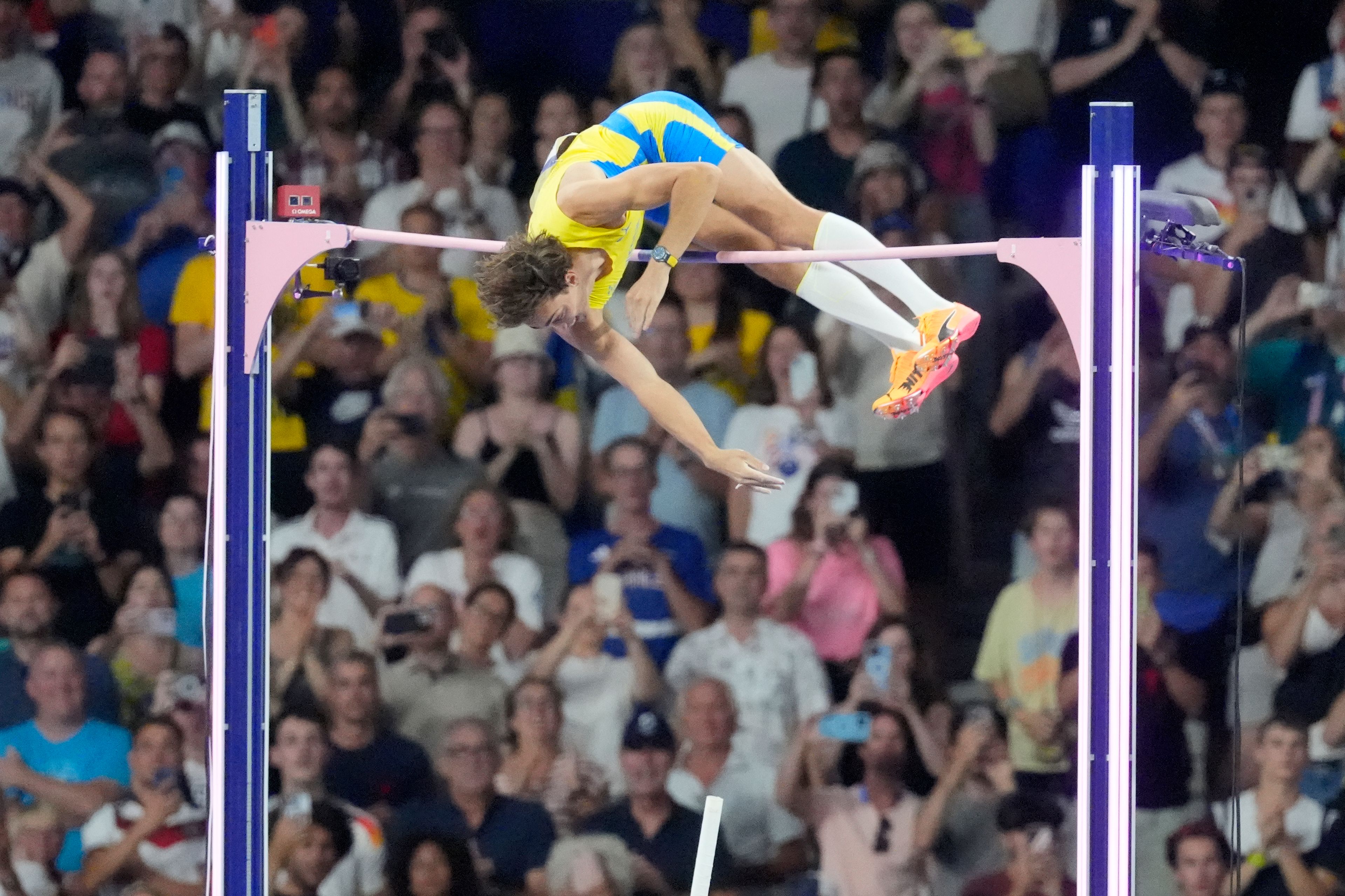 Armand Duplantis, of Sweden, clears the bar at 6.25 to set a new world record during the men's pole vault final at the 2024 Summer Olympics, Monday, Aug. 5, 2024, in Saint-Denis, France. (AP Photo/Martin Meissner)