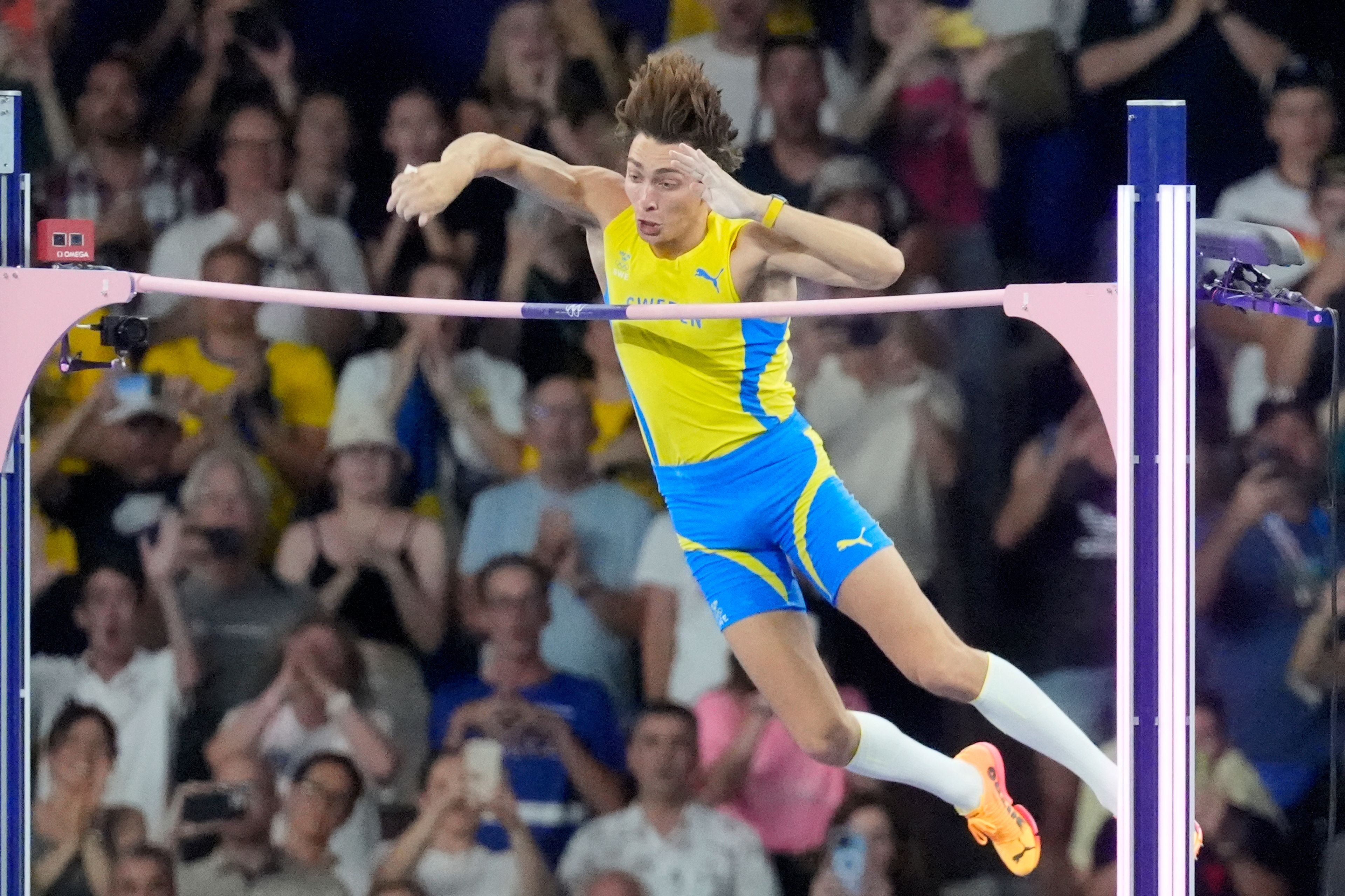 Armand Duplantis, of Sweden, clears the bar at 6.25 to set a new world record during the men's pole vault final at the 2024 Summer Olympics, Monday, Aug. 5, 2024, in Saint-Denis, France. (AP Photo/Martin Meissner)