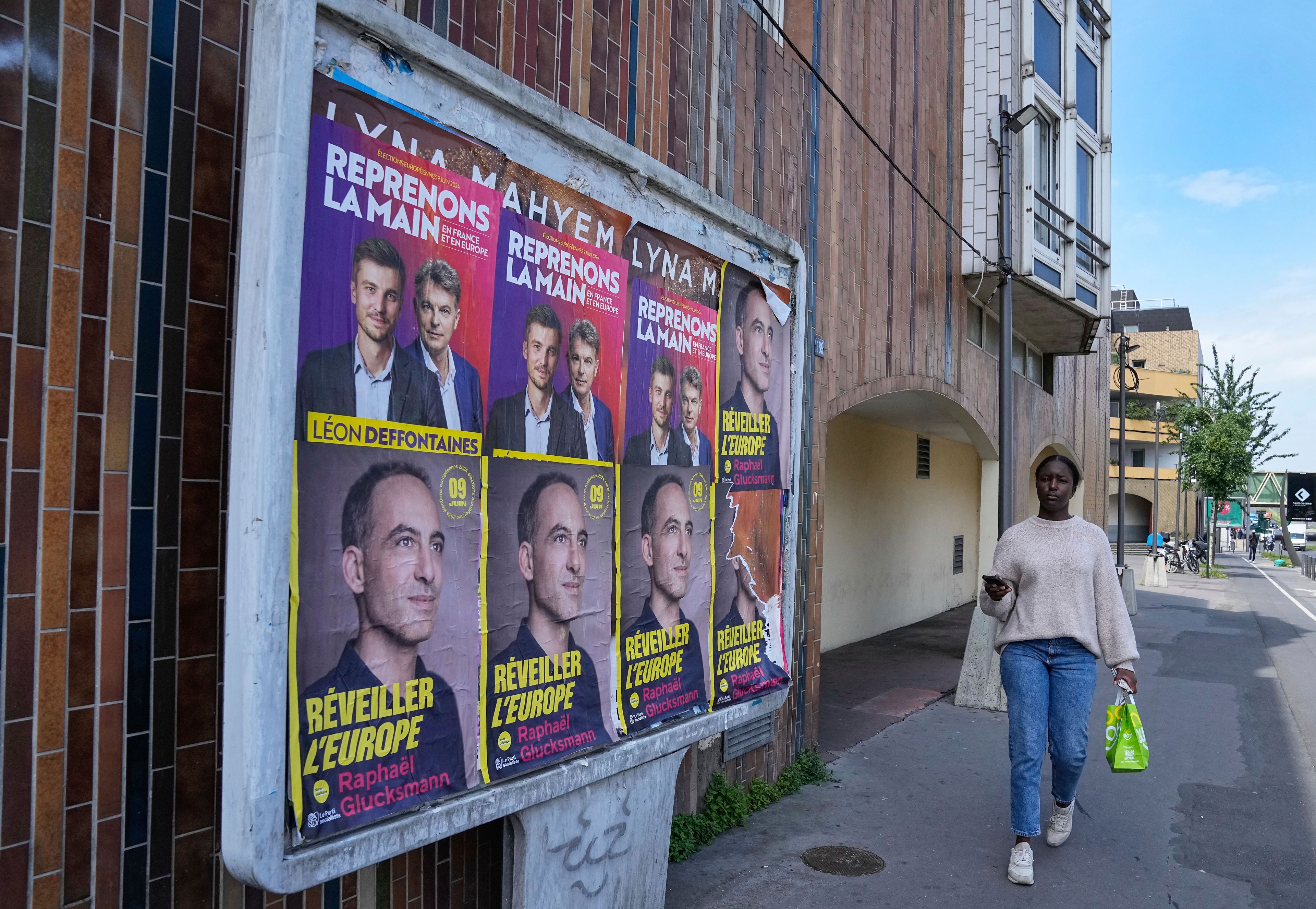 A woman walks past campaign posters for the upcoming European election in Colombes, west of Paris, Thursday, June 6, 2024. The European Election will take place on June 9.