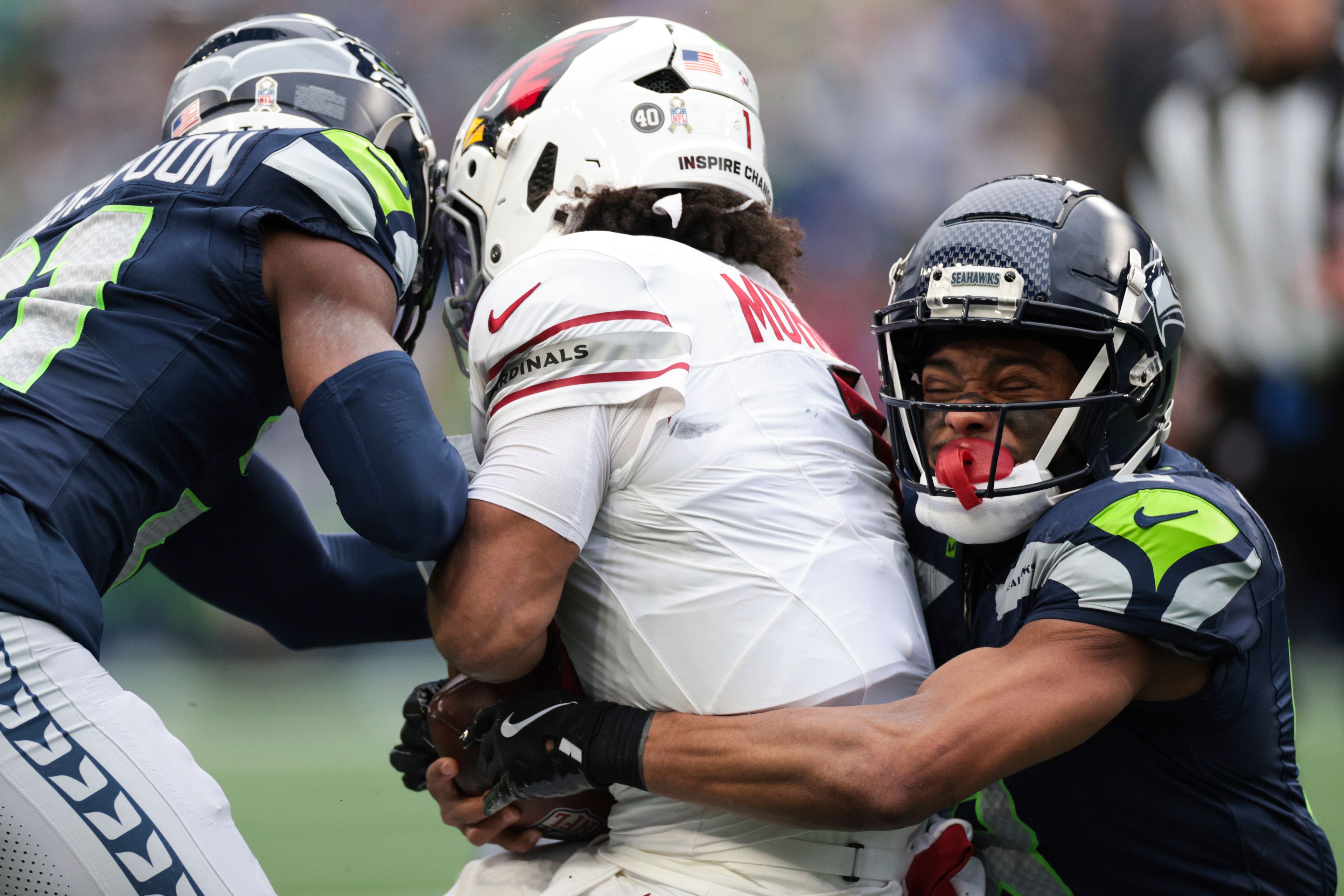 Seattle Seahawks cornerback Devon Witherspoon, left, and cornerback Coby Bryant, right, tackle Arizona Cardinals quarterback Kyler Murray during the first half of an NFL football game Sunday, Nov. 24, 2024, in Seattle. (AP Photo/Jason Redmond)