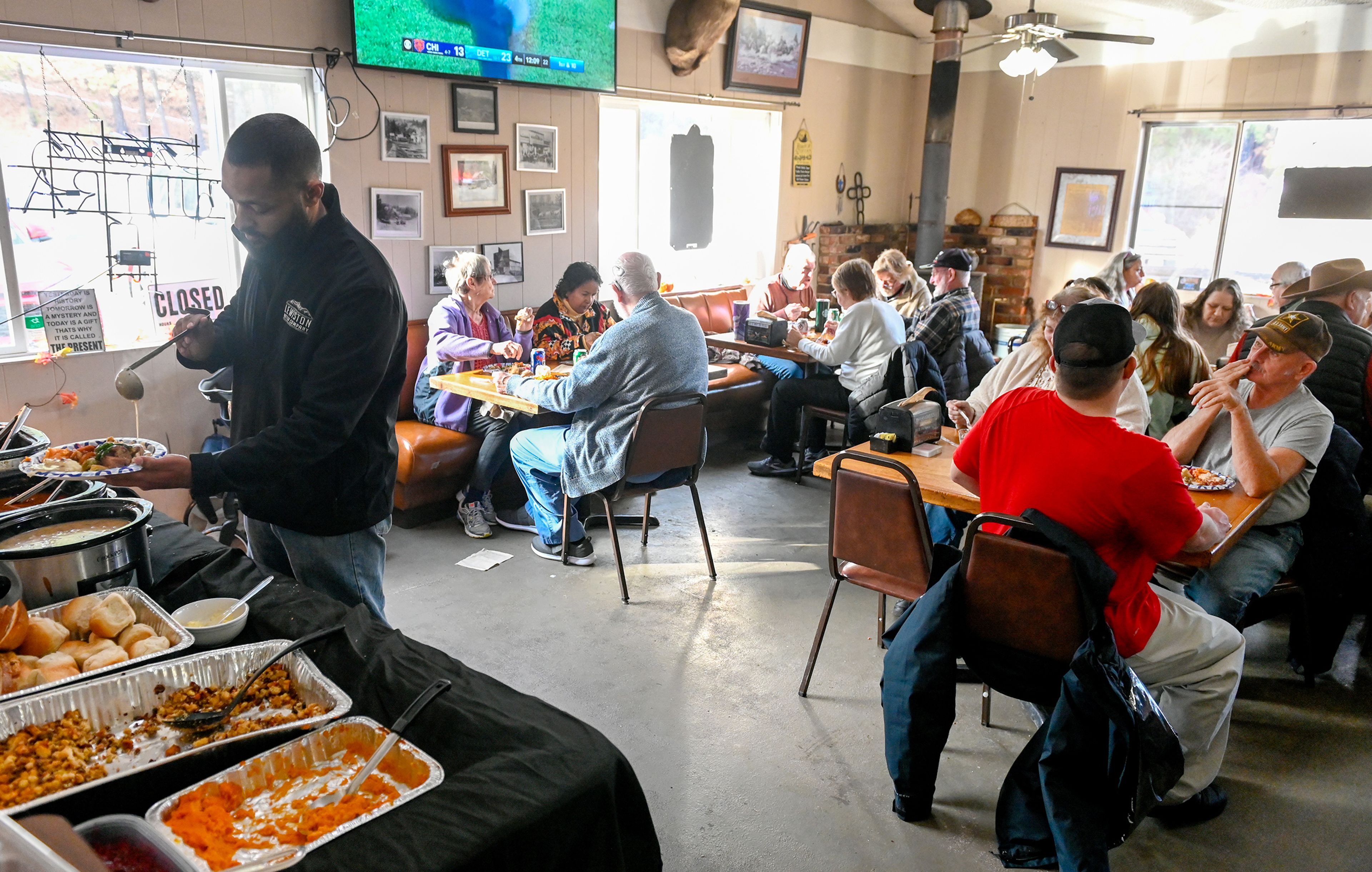 Greg Charles, left, a member of the Waha Grill family business, prepares a plate for a guest as other fill the seats of the restaurant during the annual free Thanksgiving meal on the outskirts of Lewiston.