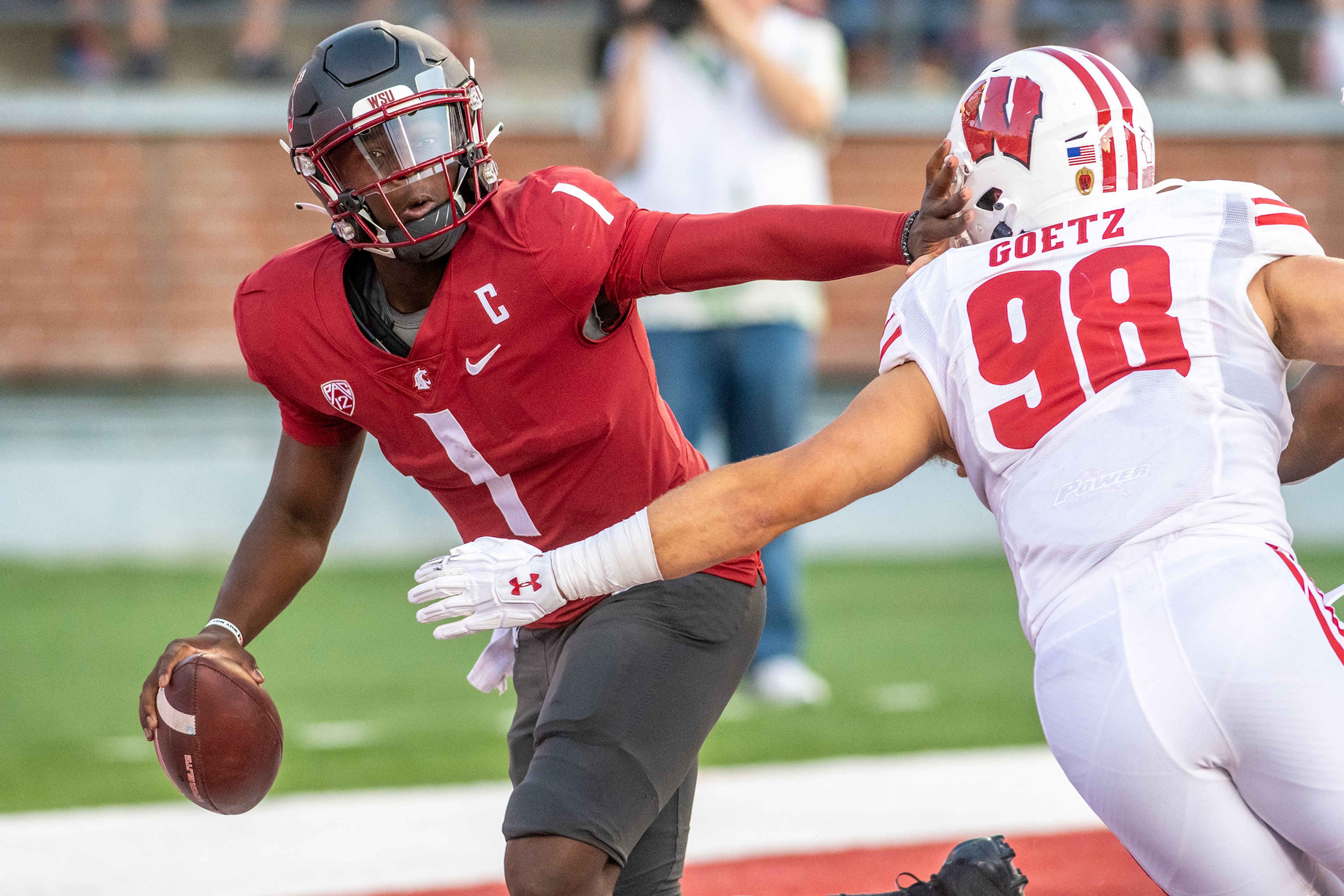 Washington State quarterback Cam Ward, left, stiff arms Wisconsin linebacker C.J. Goetz, right, after picking up a fumbled ball during a game against Wisconsin on Sept. 9 at Gesa Field in Pullman.