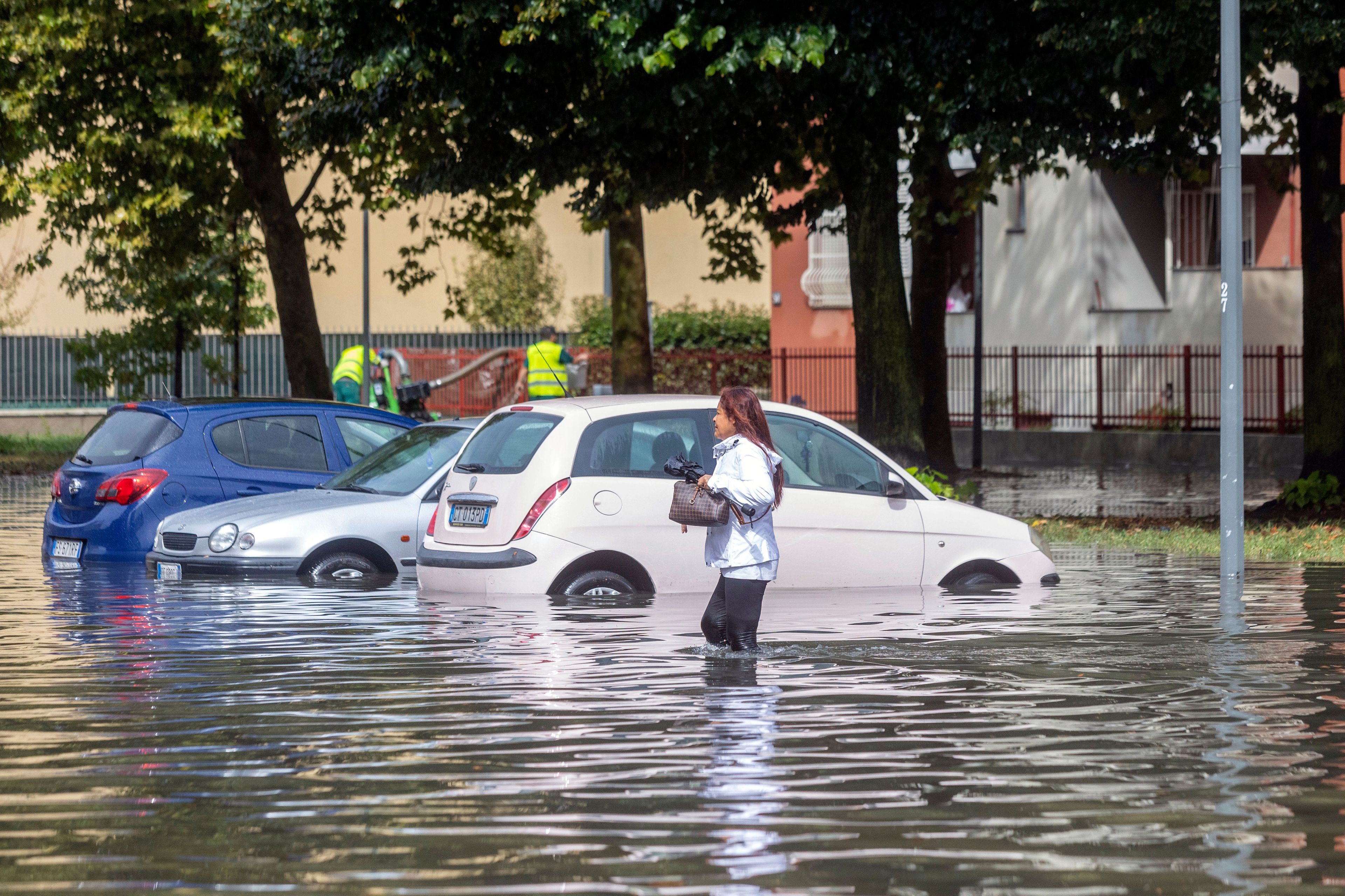 A woman wades through floodwater due to heavy rain in a street in Milan, Italy, Thursday Sept. 5, 2024.