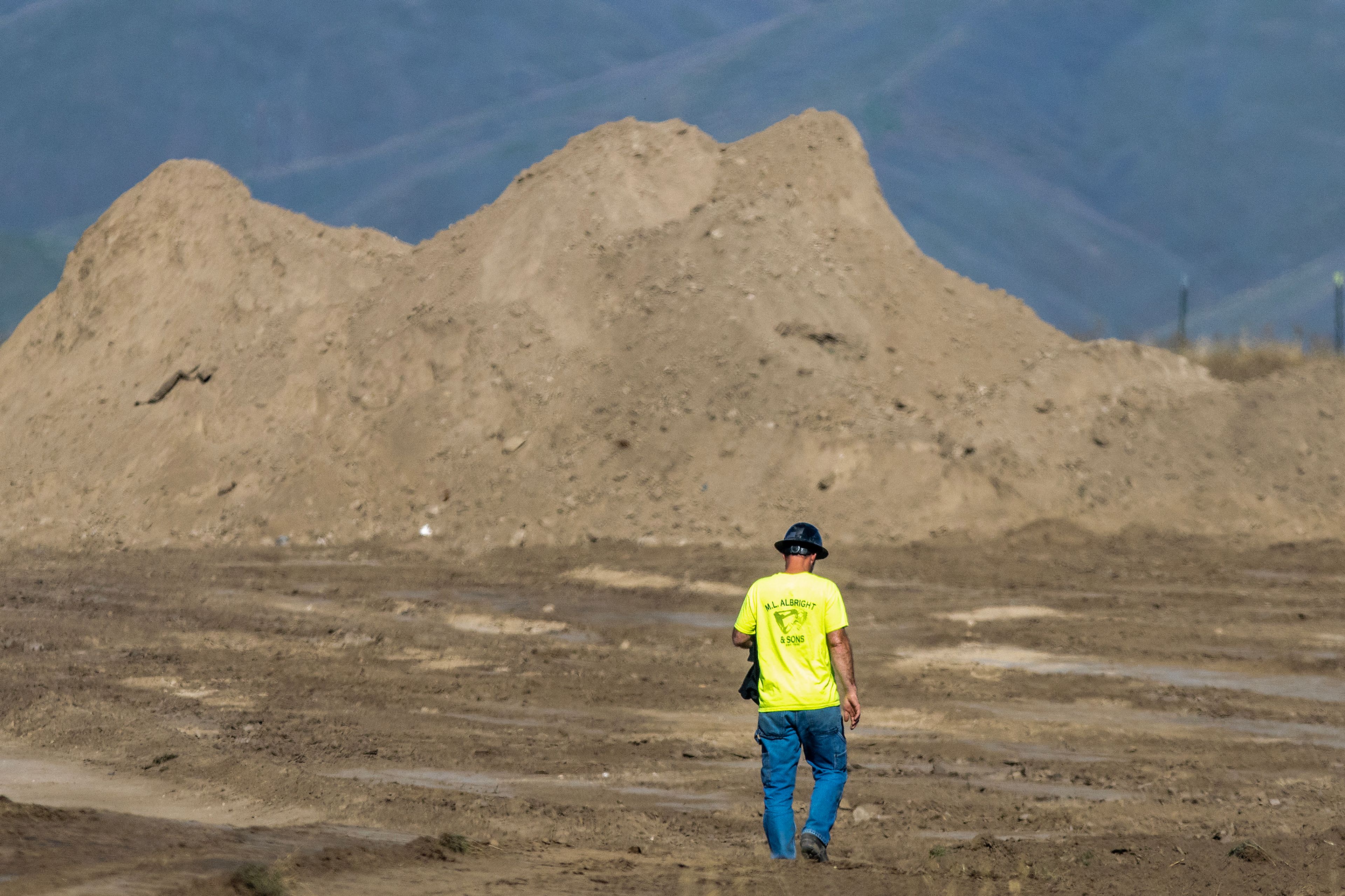 A worker walks across what will be the future athletic fields at Lewiston High School.