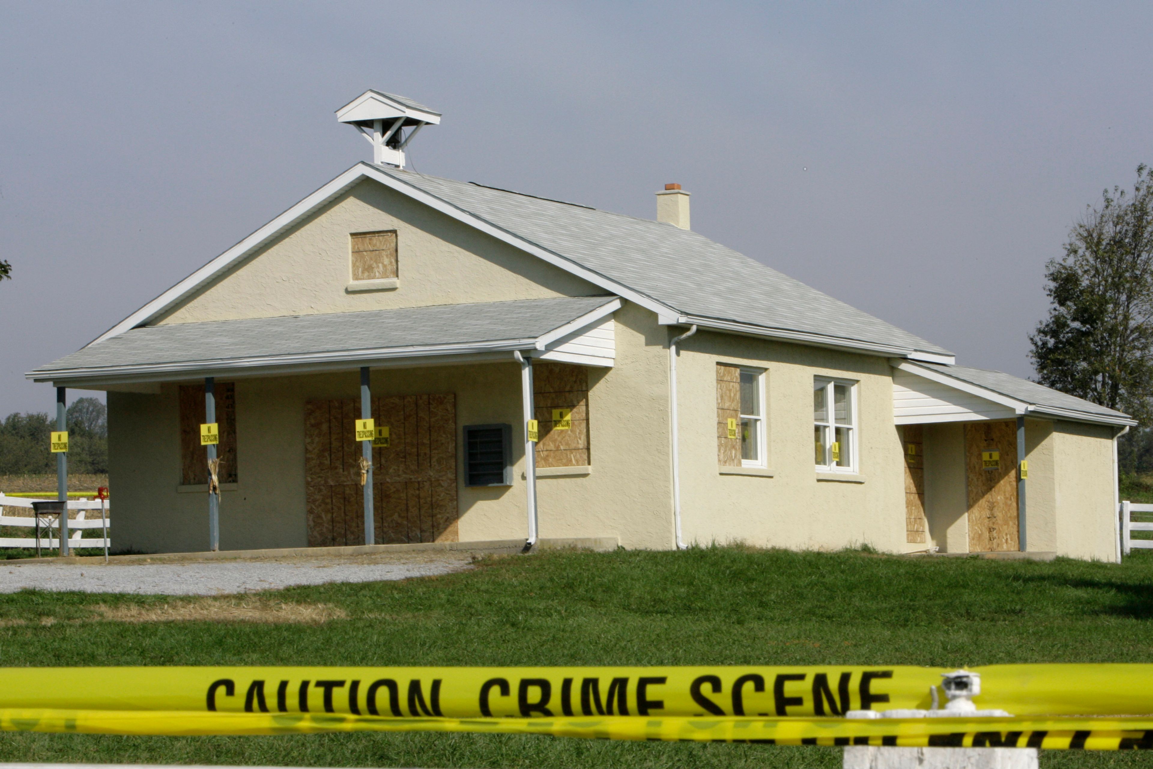 FILE - Crime scene tape is seen surrounding the boarded-up schoolhouse in Nickel Mines, Pa., Wednesday Oct. 4, 2006 where a gunman killed several people on Monday.