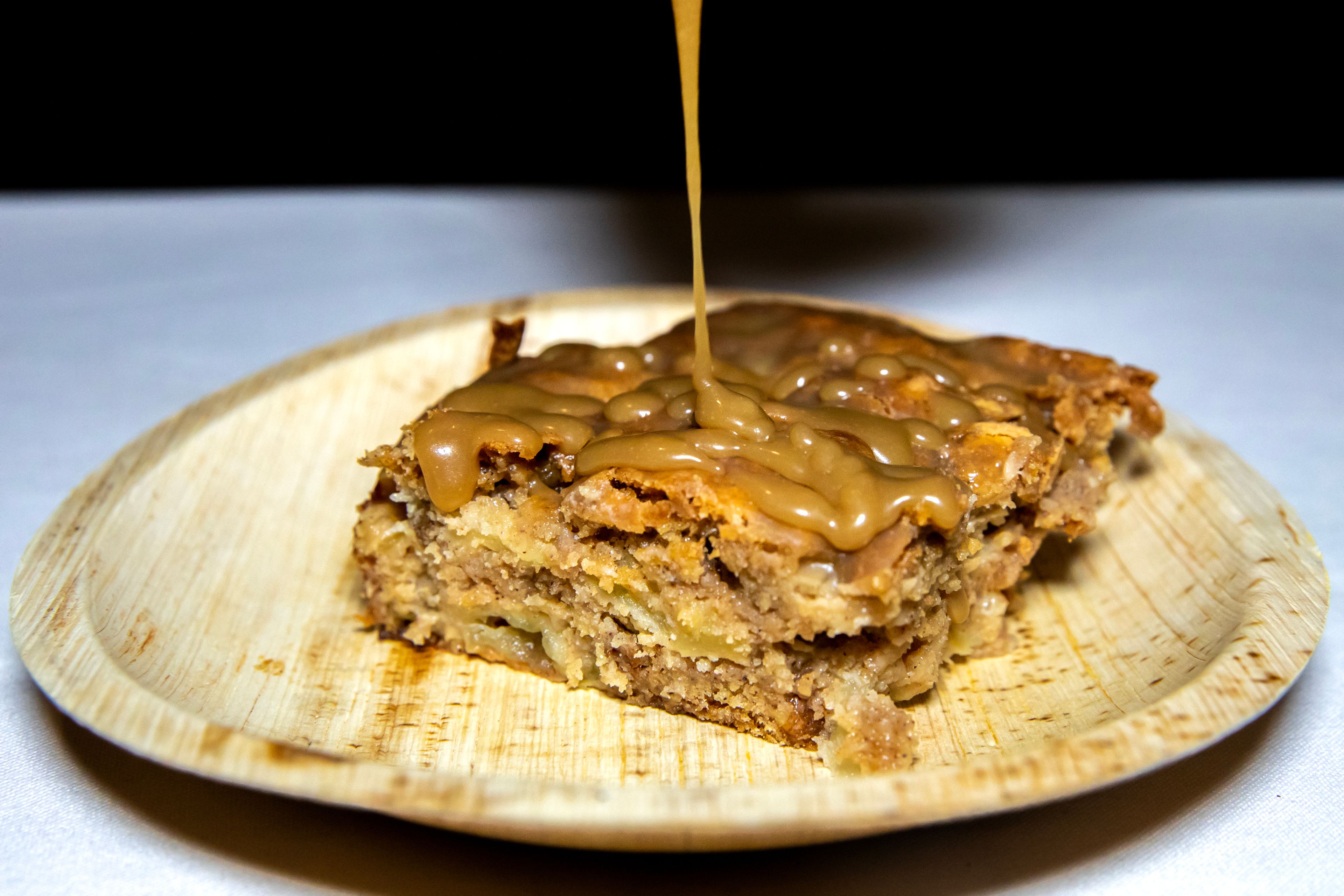 Butterscotch syrup is drizzled over an apple cake Thursday, Dec. 14, in Lewiston.