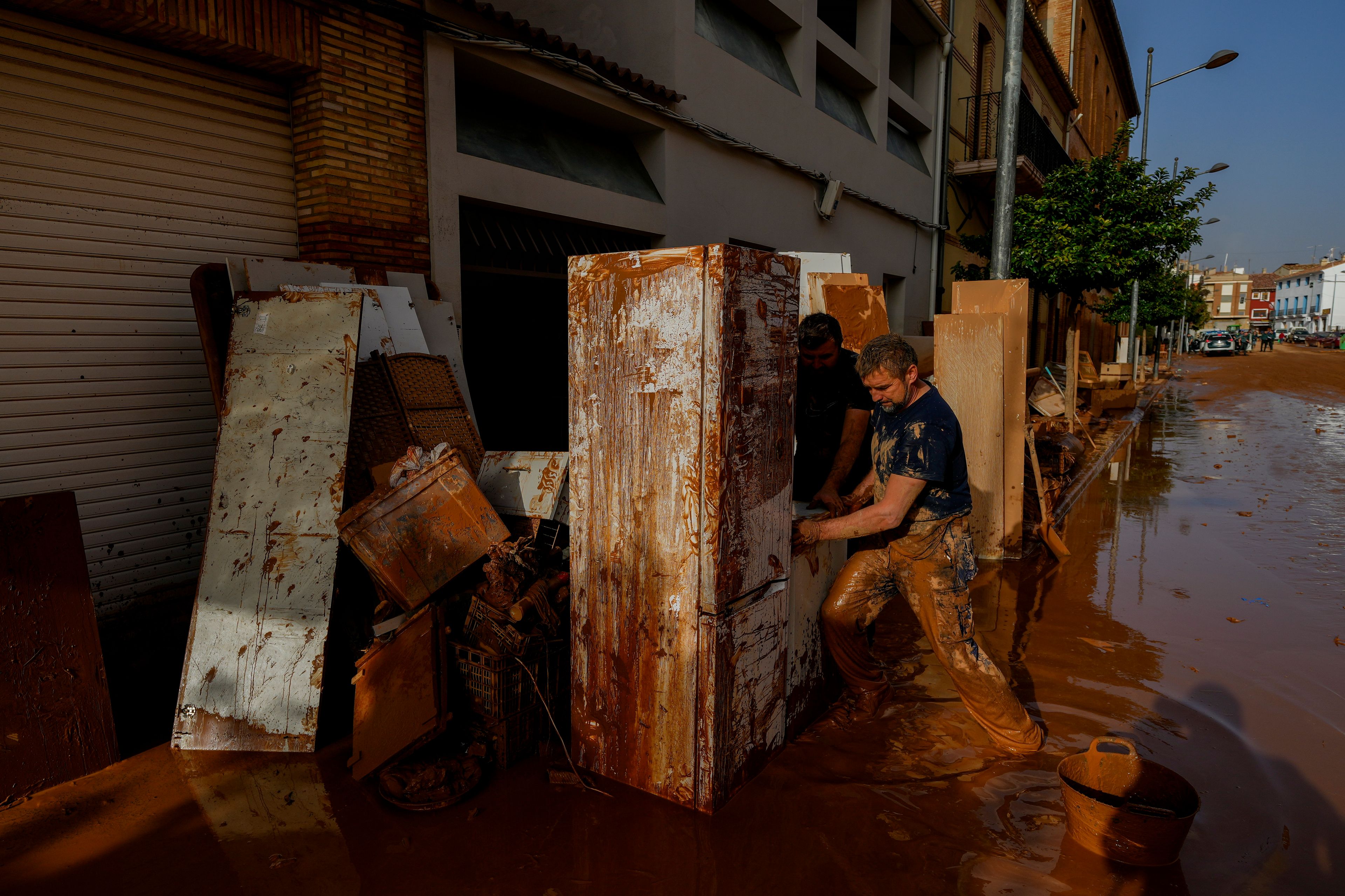 A man cleans his house hit by floods in Utiel, Spain, Wednesday, Oct. 30, 2024. (AP Photo/Manu Fernandez)