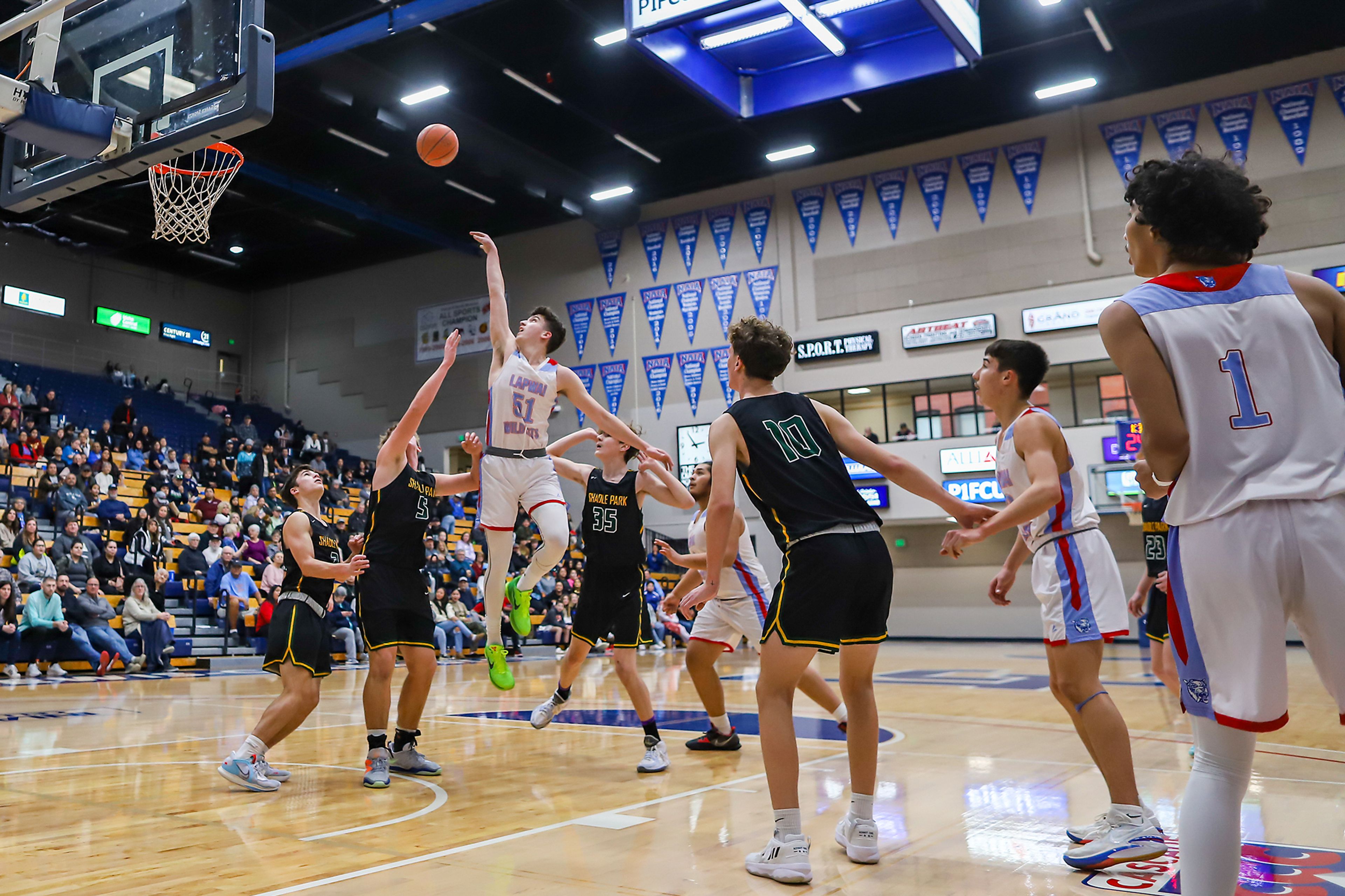 Lapwai guard Kase Wynott, in green shoes, shoots during Thursday’s Avista Holiday Tournament boys basketball final against Shadle Park at the P1FCU Activity Center on the campus of Lewis-Clark State College.