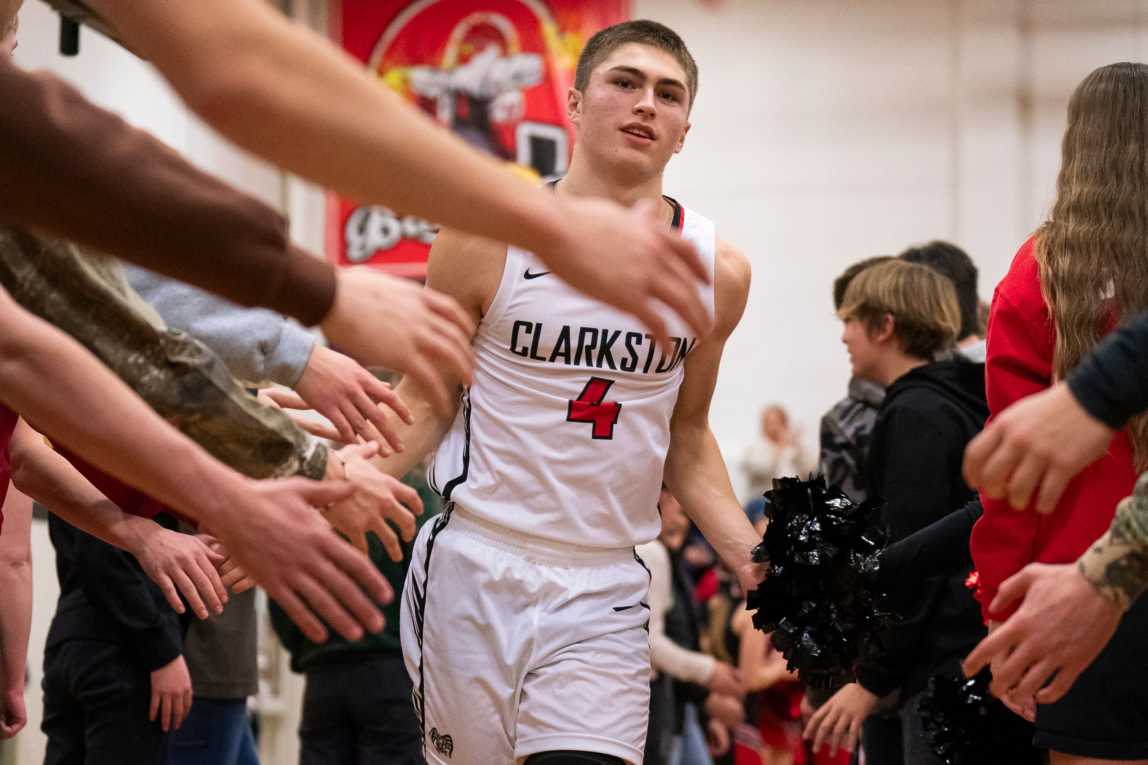 Clarkston’s Xander Van Tine (4) high-fives fans as he is being introduced before their game against West Valley on Tuesday at Clarkston High School.