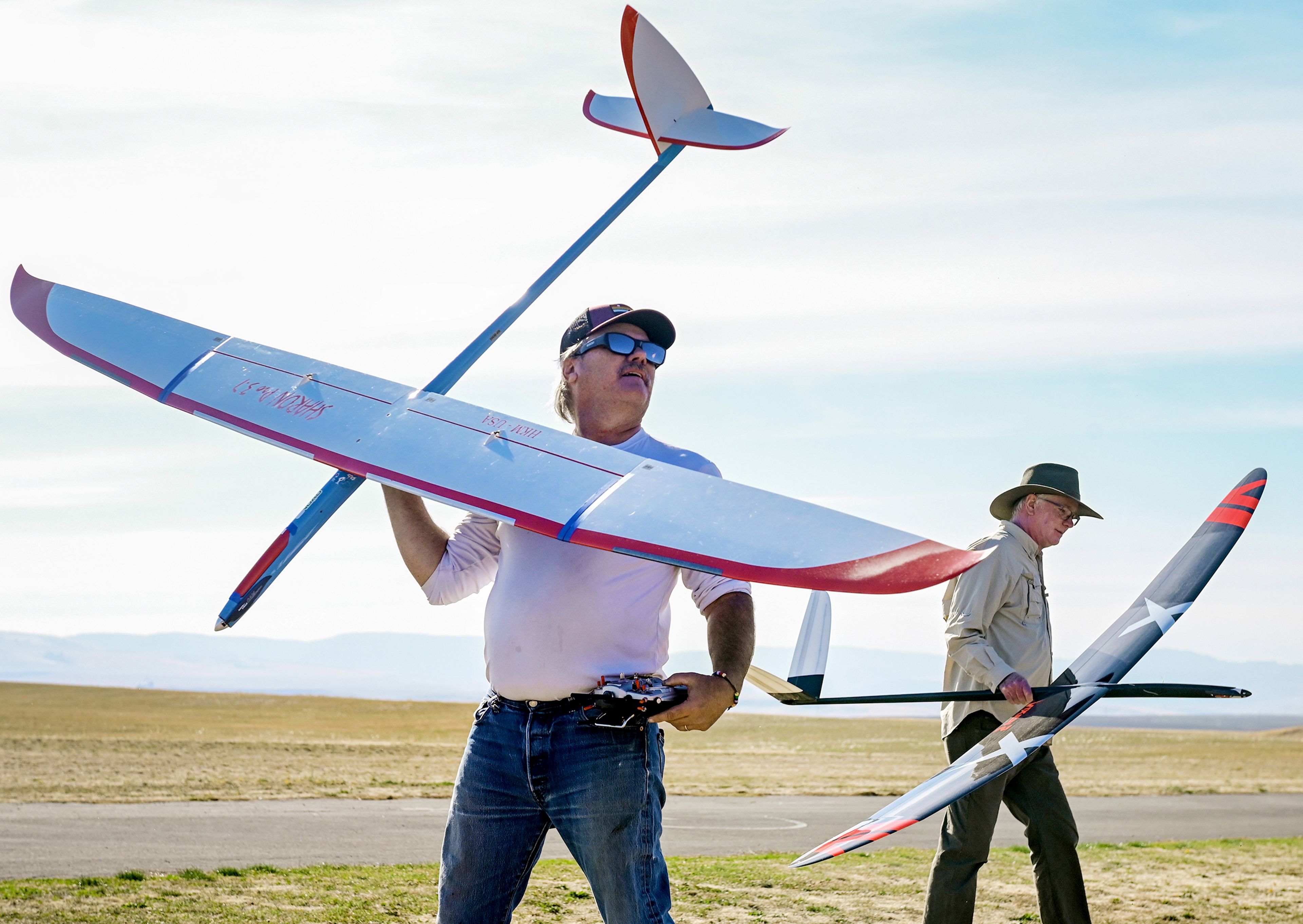 Lewis Clark RC Model Club president Tim Lynch, left, and member Dave Hagelganz carry remote control sailplanes to and from the runway Saturday during the club�s Fun Fly and Open House at Mann Lake in the east Lewiston Orchards. The event will continue Sunday from 9 a.m. to 3 p.m. with  flight demonstrations, competitions and training flights.,