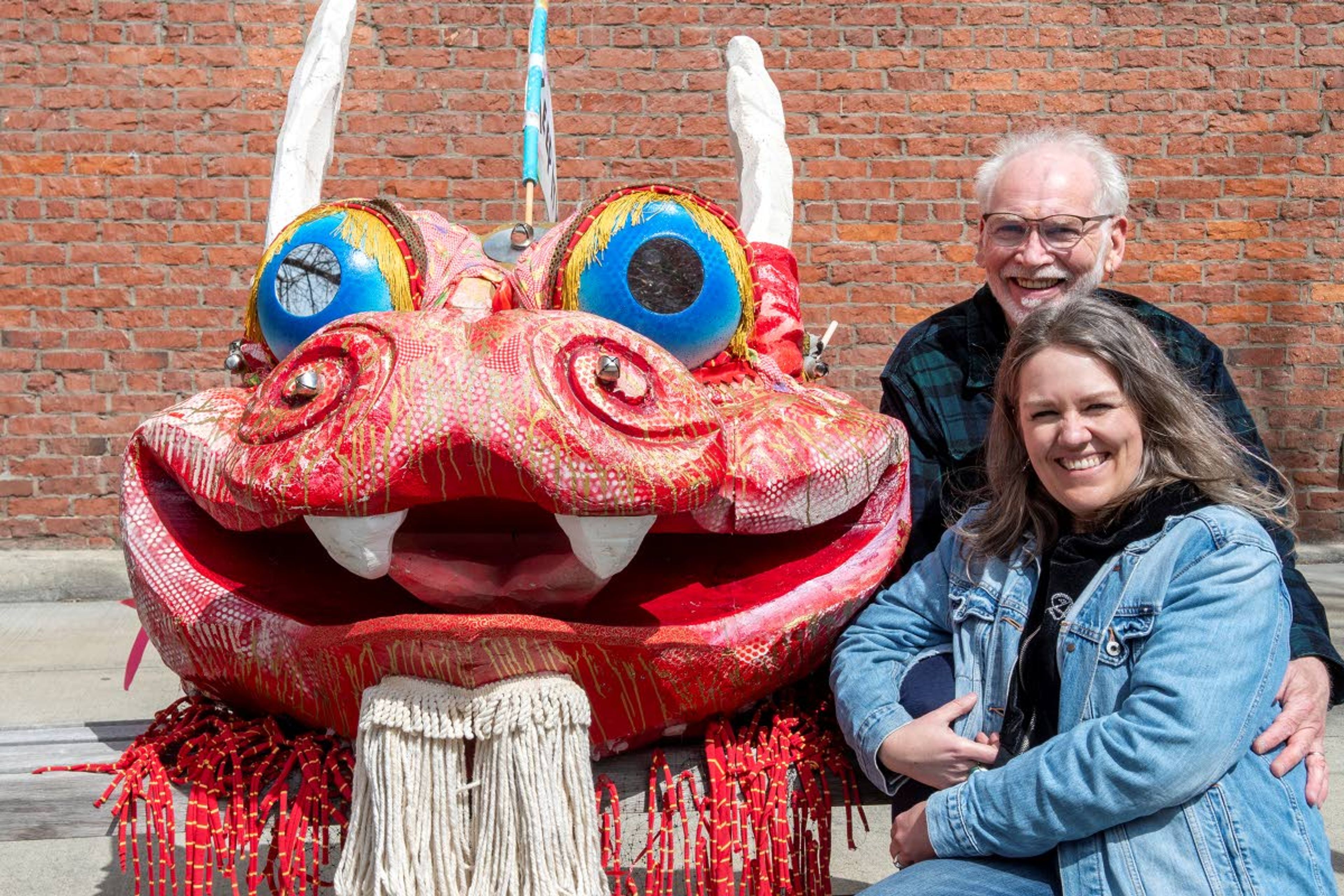 Marc Lawrence and his wife, Jill Lawrence, pose next to the Wild Thang dragon in Friendship Square in Moscow.