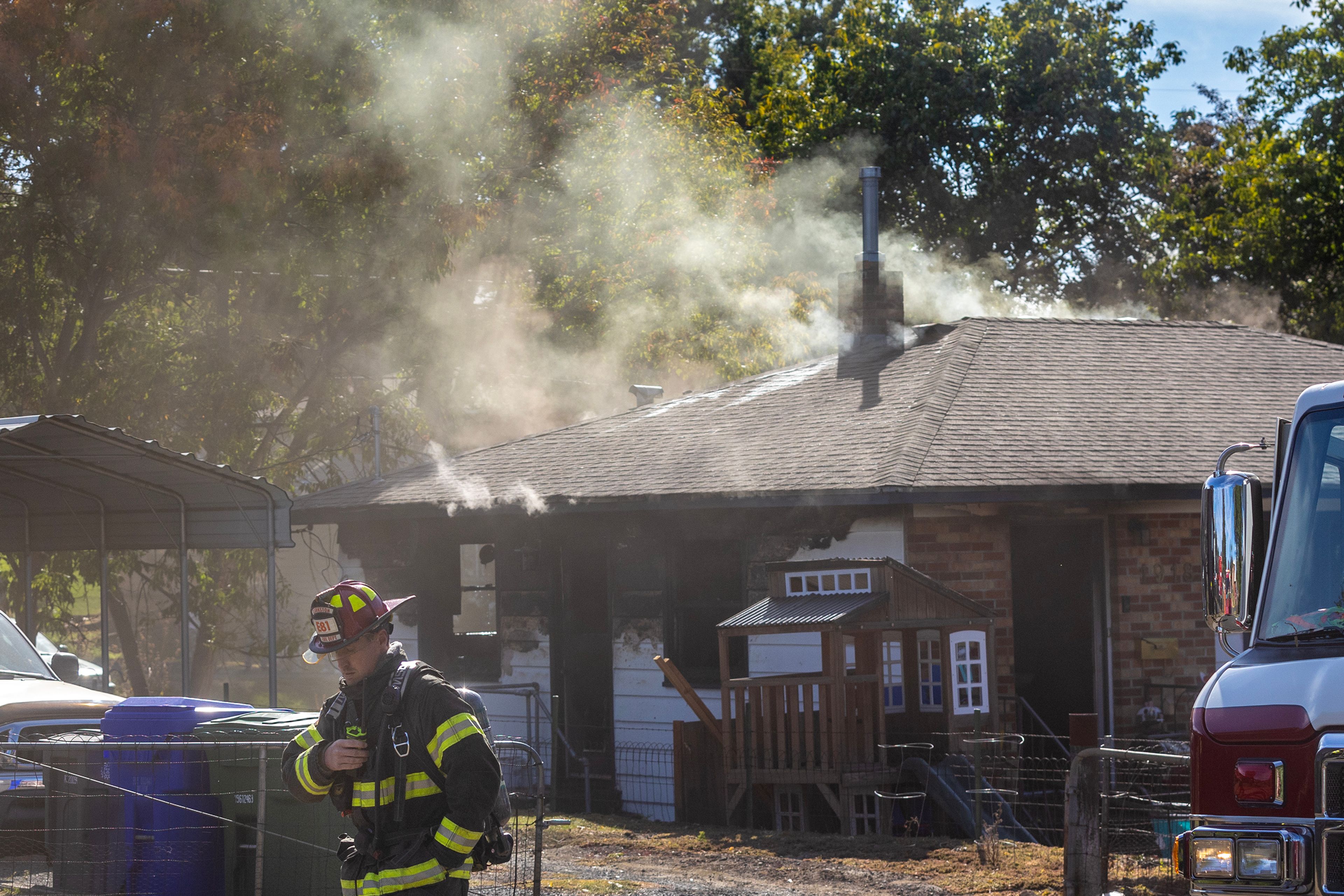 A Lewiston Firefighter walks past a smoking house at the scene of a structure fire Monday on the 1900 block of 13th Avenue in Lewiston.