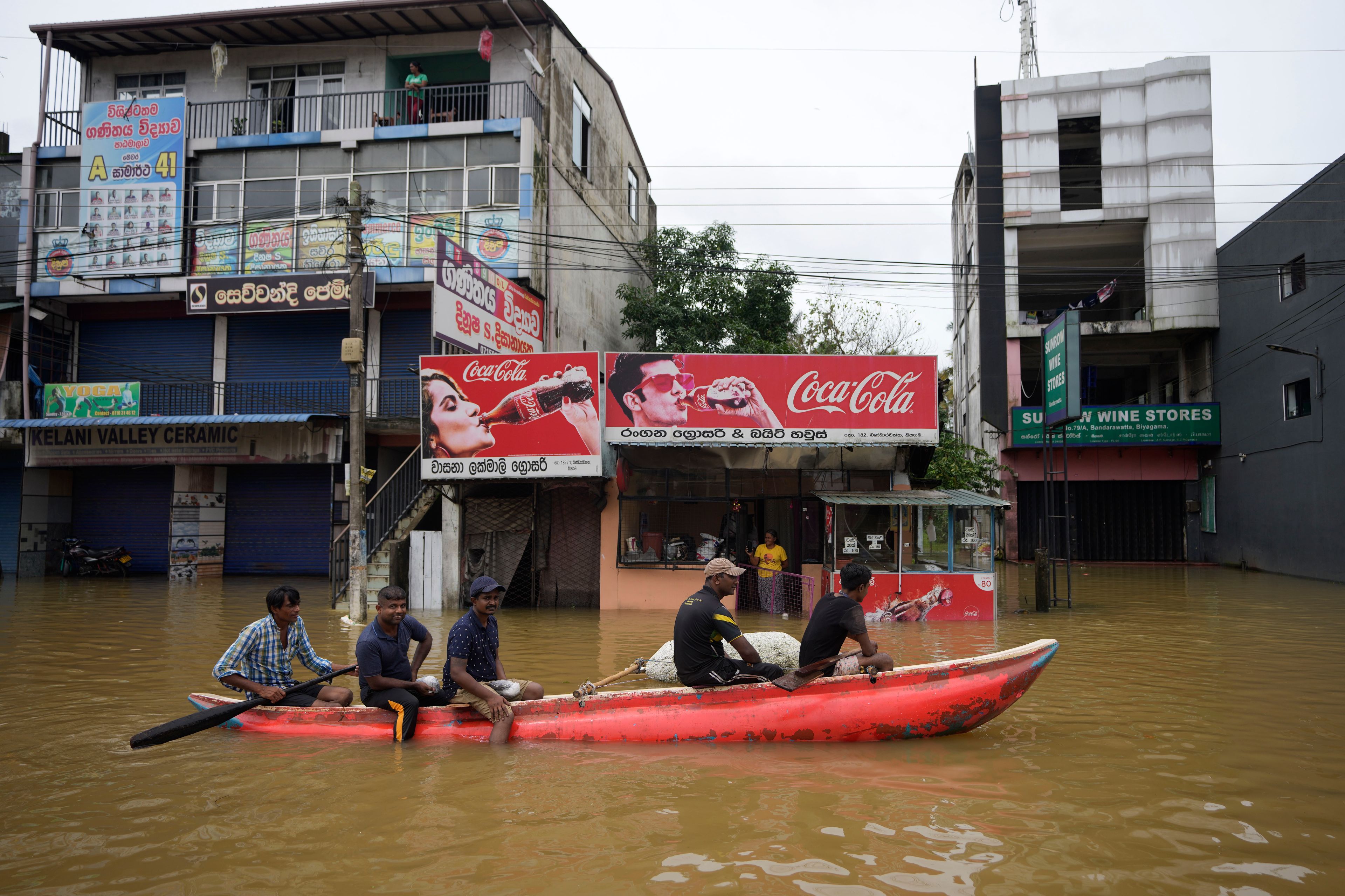 People use a boat to cross a flooded street in Biyagama, a suburb of Colombo, Sri Lanka, Monday, Jun. 3, 2023. Sri Lanka closed schools on Monday as heavy rains triggered floods and mudslides in many parts of the island nation, killing at least 10 people while six others have gone missing, officials said.