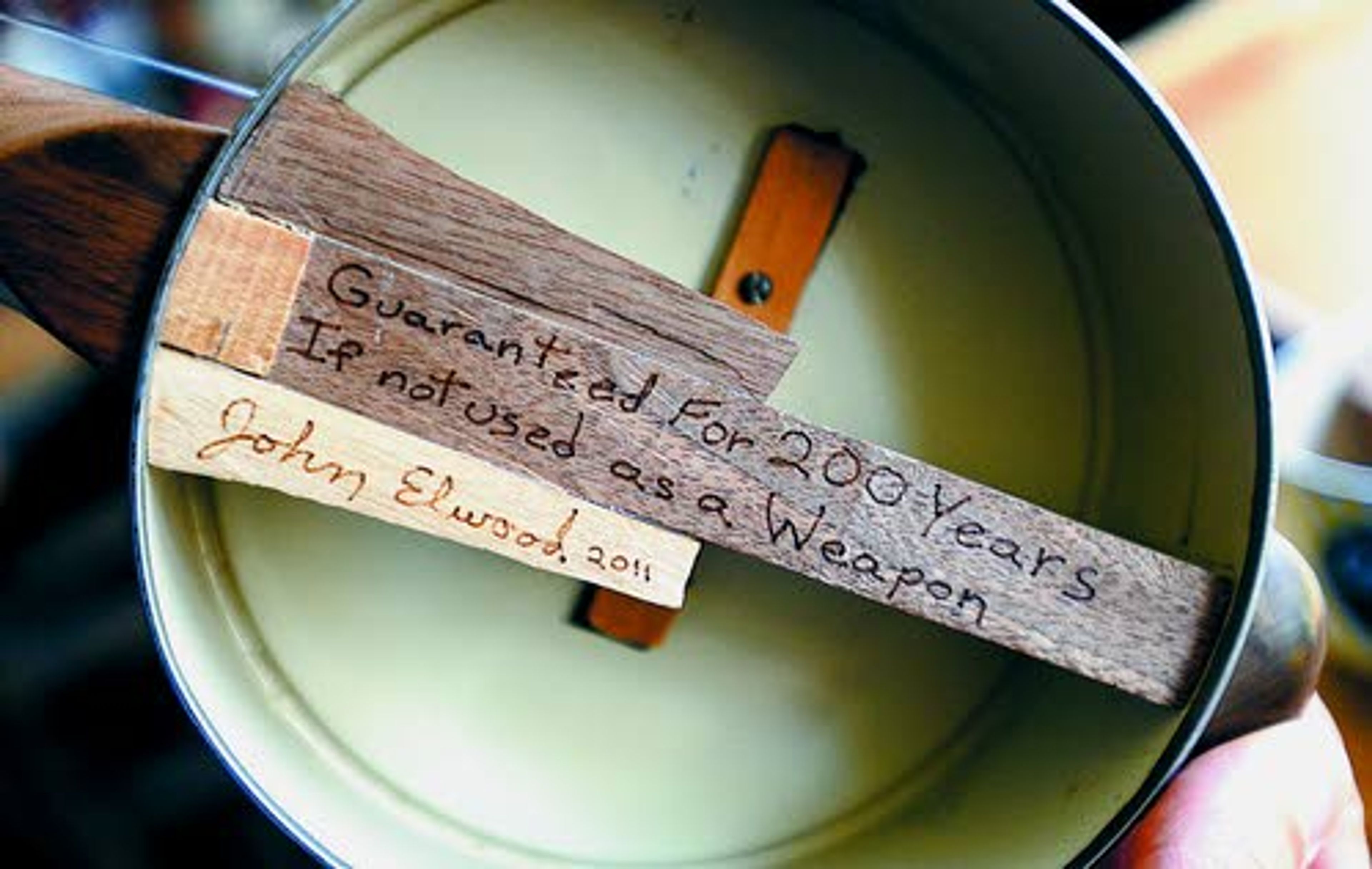 ABOVE: Living in the quiet country, John Elwood has a location seemingly made for creating musical instruments in his cozy, sunlit workshop. TOP RIGHT: Elwood makes sturdy “canjos” from Cougar Gold cheese cans. RIGHT: This Elwood canjo has a 200-year warranty.