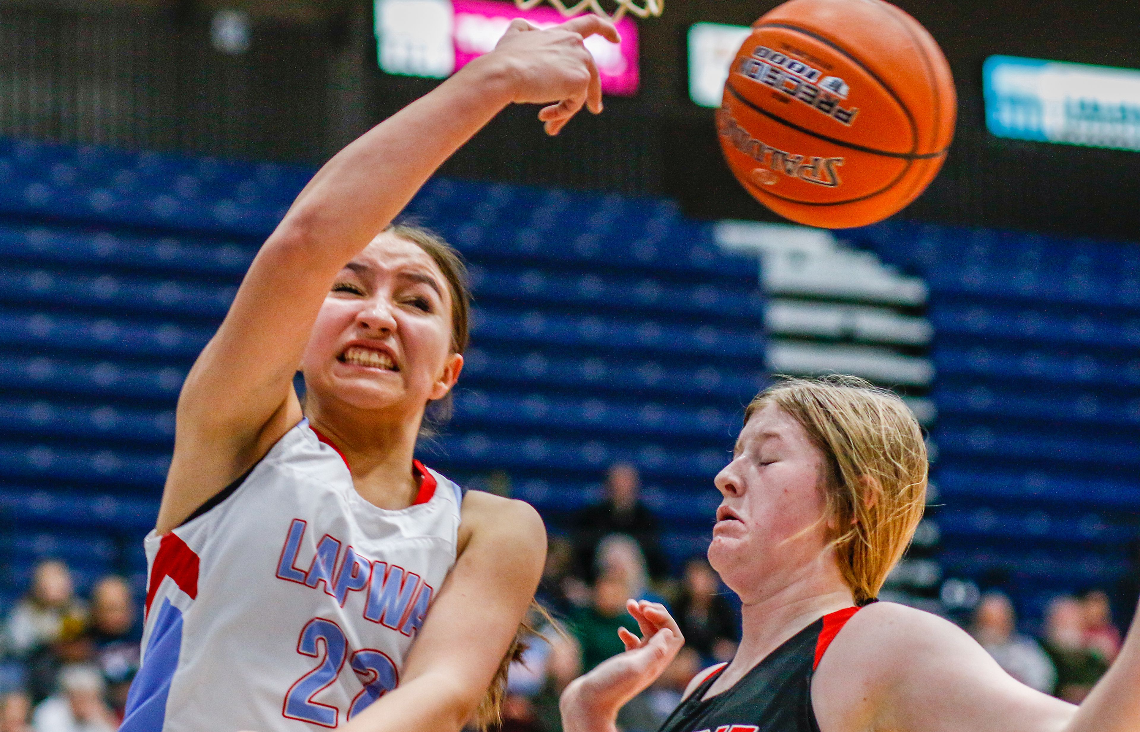 Lapwai shooting guard Taya Yearout, left, keeps a play alive with an over-the-shoulder pass as Prairie guard/post Hailey Hanson defends during Thursday's Avista Holiday Tournament girls basketball final at the P1FCU Activity Center in Lewiston.