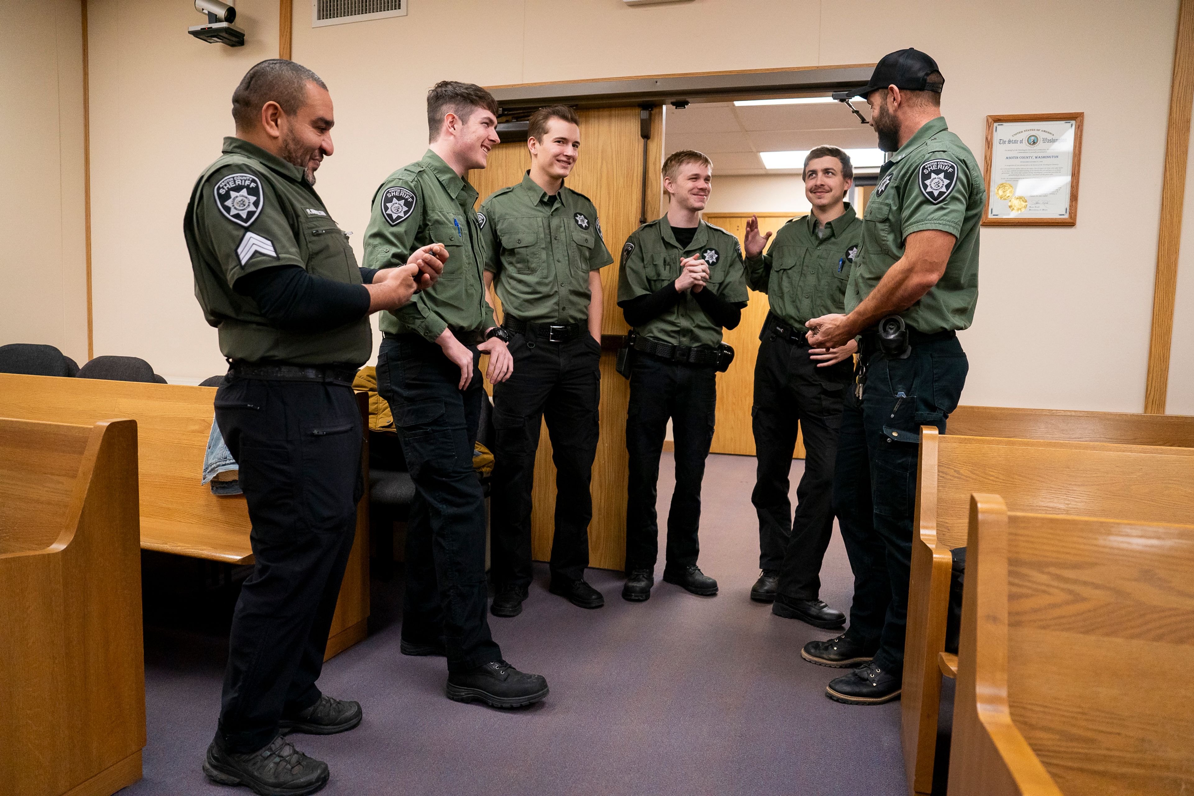 Sergeant Rashid Bensultana, left, and jail commander Nate Uhlorn, right, speak with new correction deputies before they are sworn in on Thursday afternoon inside the Asotin County Courthouse Annex.