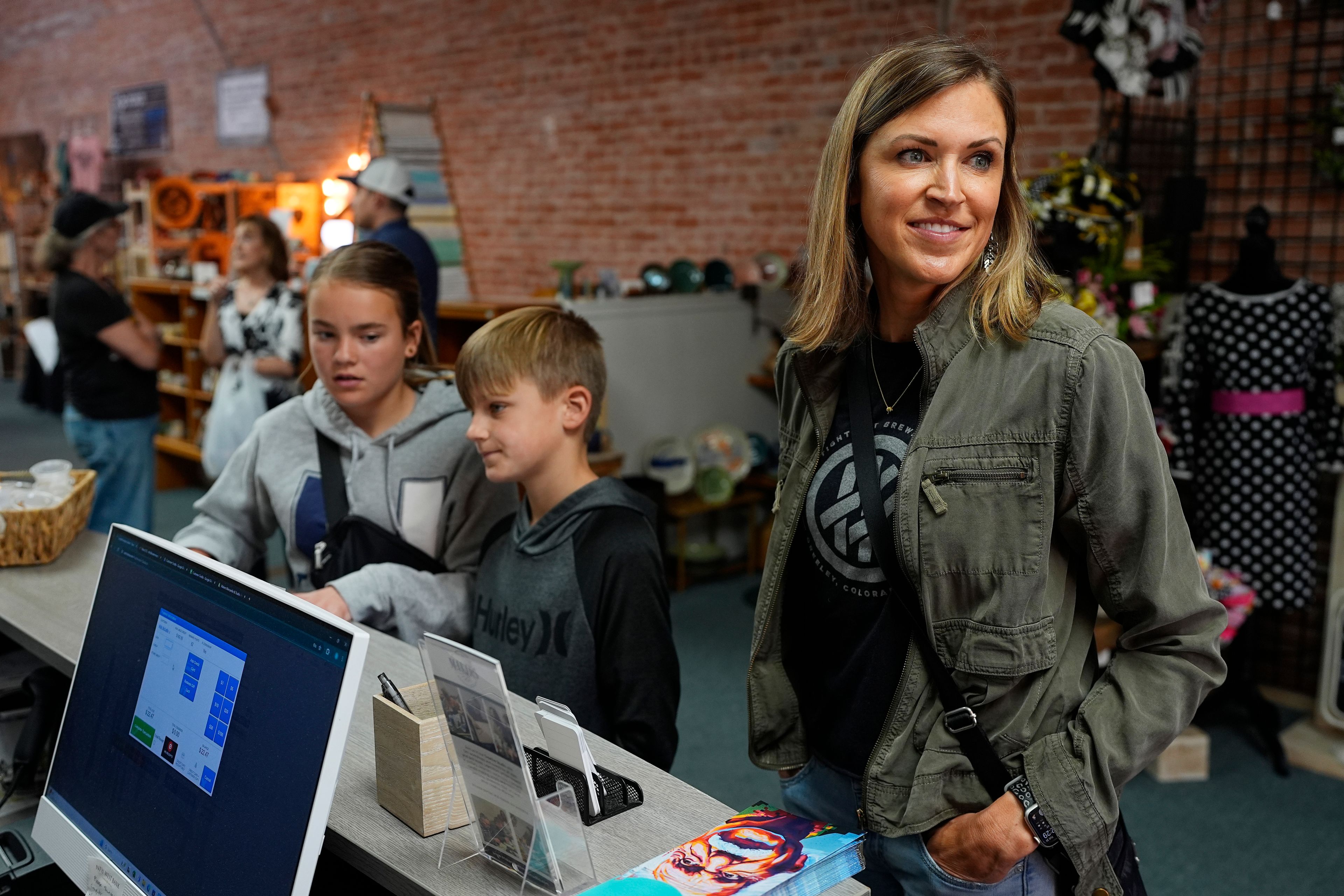 Kristina McGuffey with her 12-year-old daughter, Molly and 9-year-old son Wyatt, speaks while making a purchase at a downtown craft collective Tuesday, May 21, 2024, in Greeley, Colo. (AP Photo/David Zalubowski)