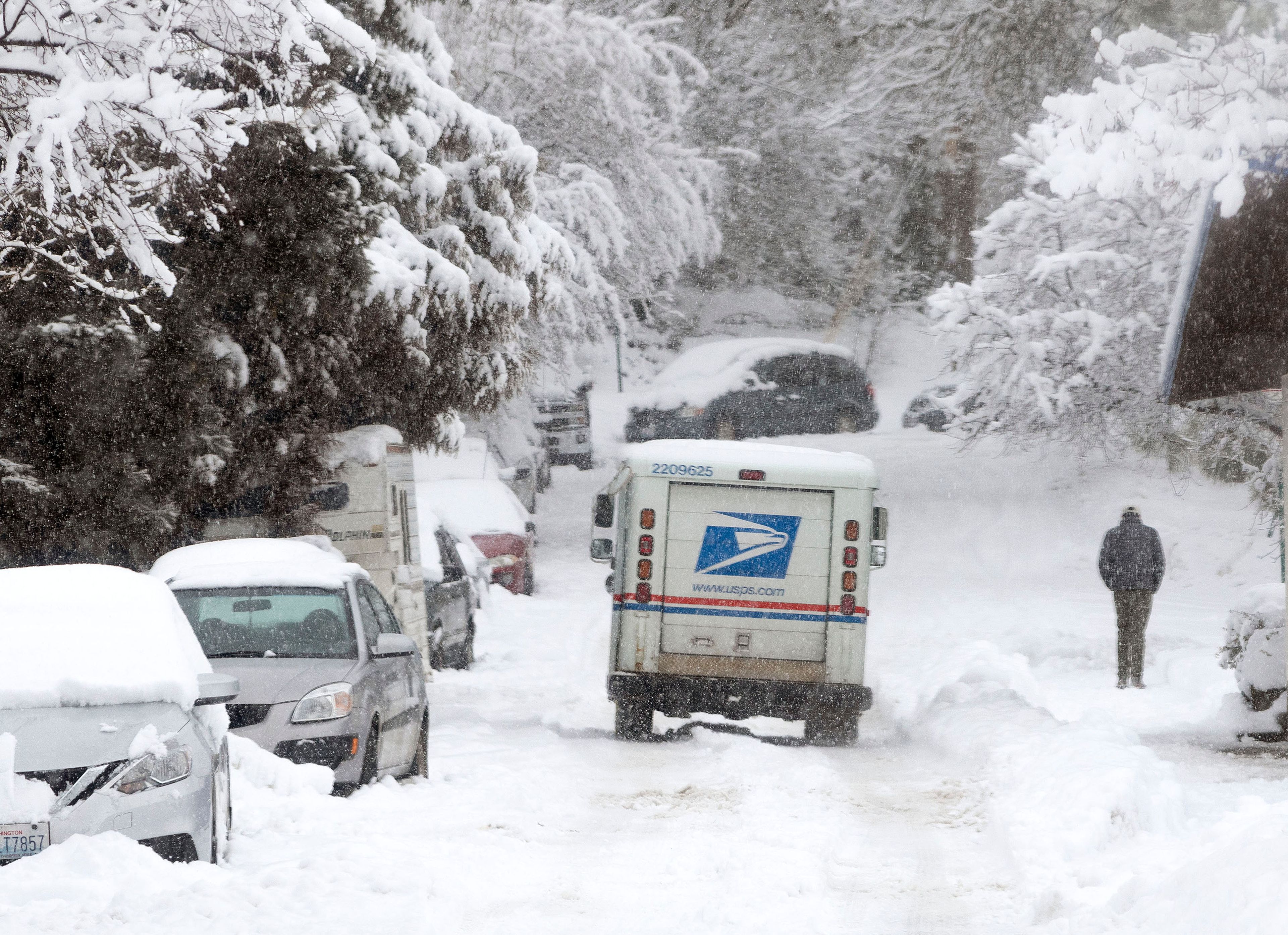 A U.S. Postal Service truck drives through the snow on Wednesday on Morton Street in Pullman.