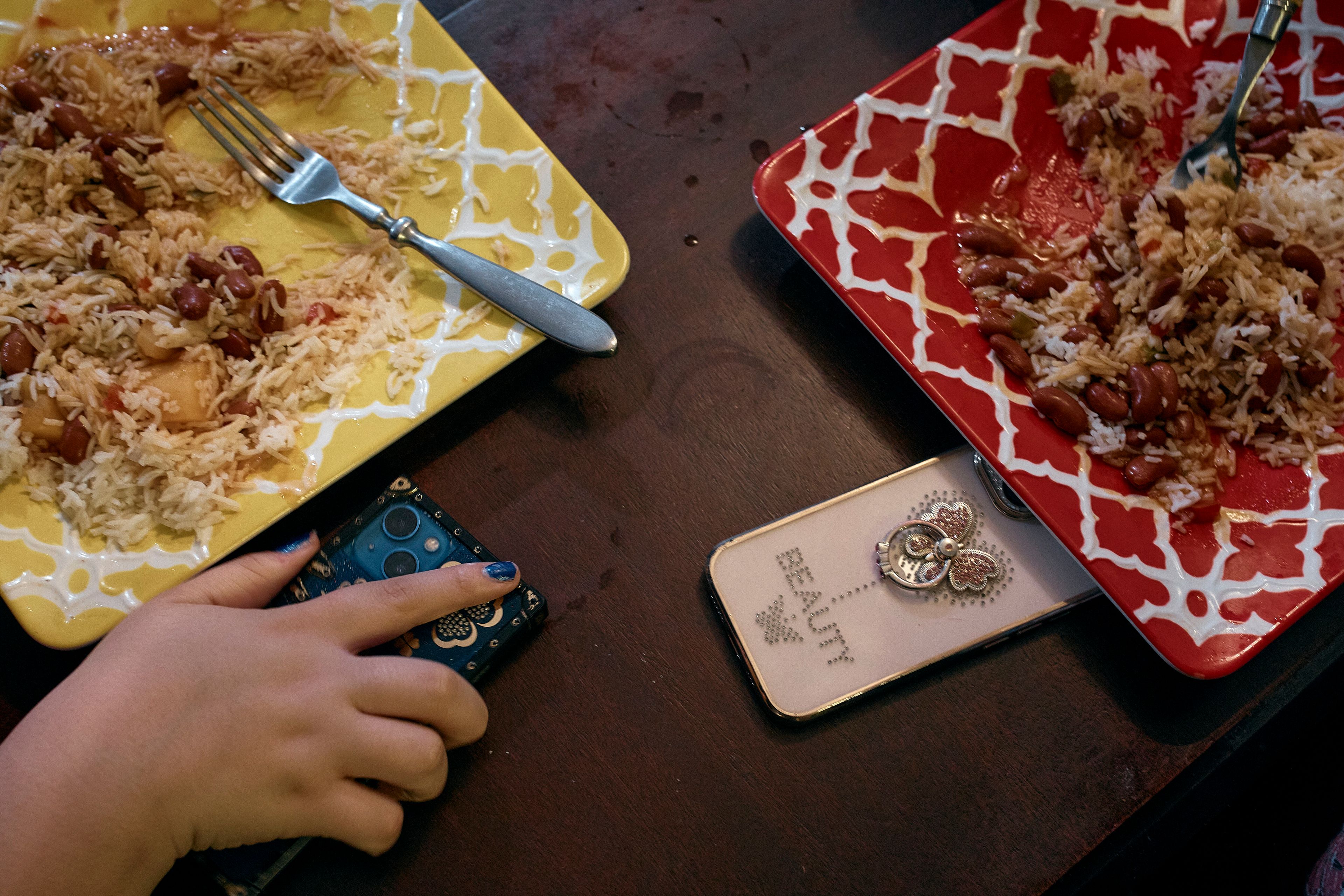 Gionna Durham, 13 , left, holds her phone as she has dinner with her sister Gabriela Durham, 17 years old, unseen, on Saturday, Jan. 27, 2024, in New York. Concerns about children and phone use are not new. But there is a growing realization among experts that the COVID-19 pandemic fundamentally changed the relationship kids have with social media. As youth coped with isolation and spent excessive time online, the pandemic effectively carved out a much larger space for social media in the lives of American children.