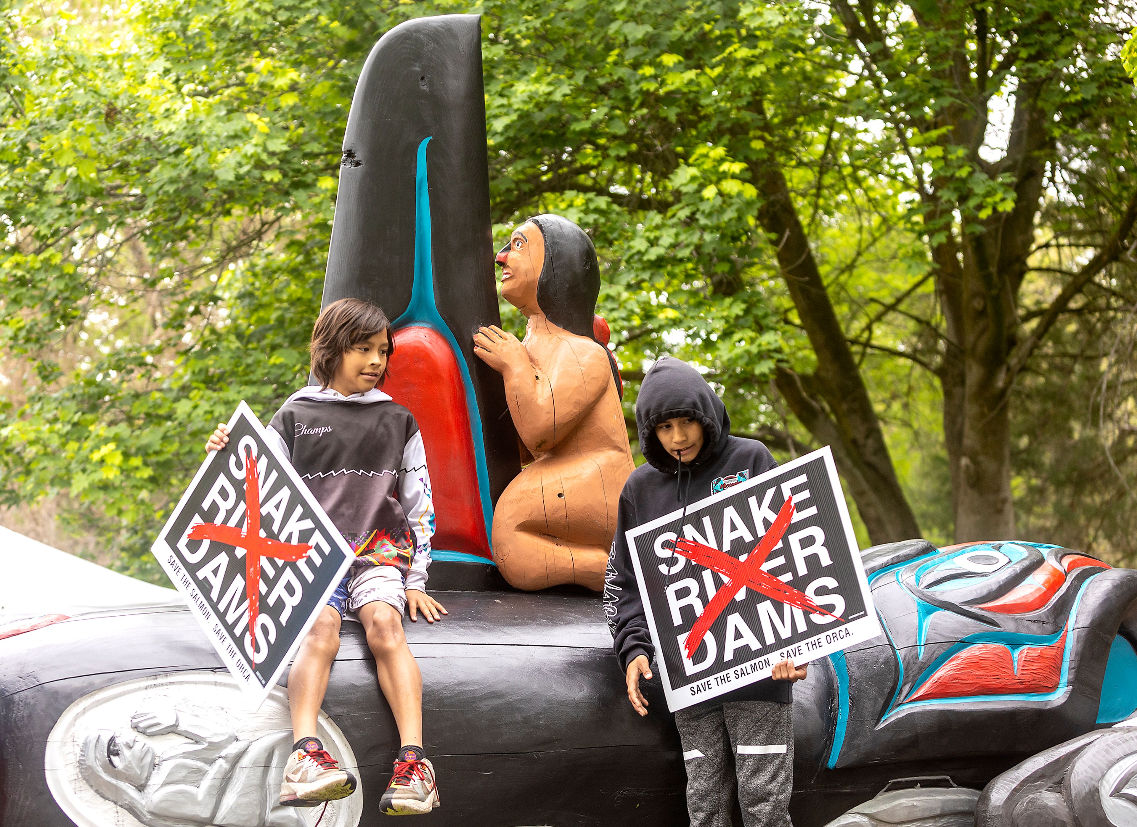 Kids climb up on the trailer bed carrying signs calling for breaching of the Snake River Dams at Hells Gate State Park in Lewiston on Monday.