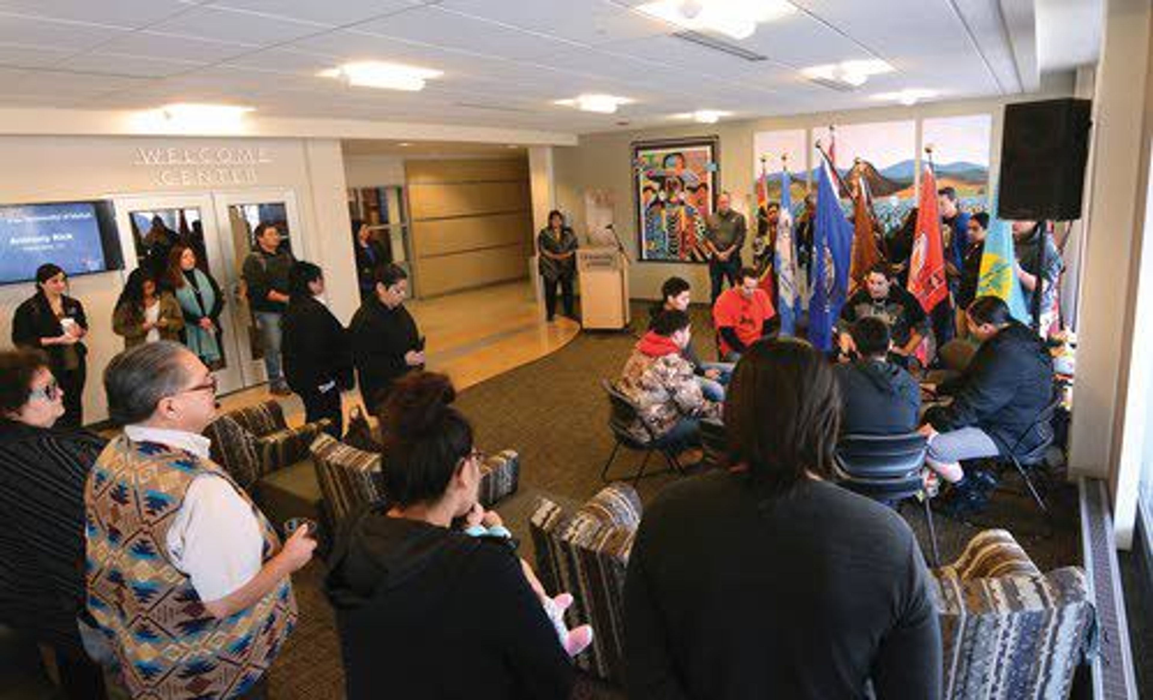 A crowd gathers in the Tribal Nations Lounge at the Bruce M. Pitman Center for the dedication of 10 tribal flags that will be permanently displayed in the lounge. The event kicked off Native American Heritage month at the University of Idaho in Moscow.