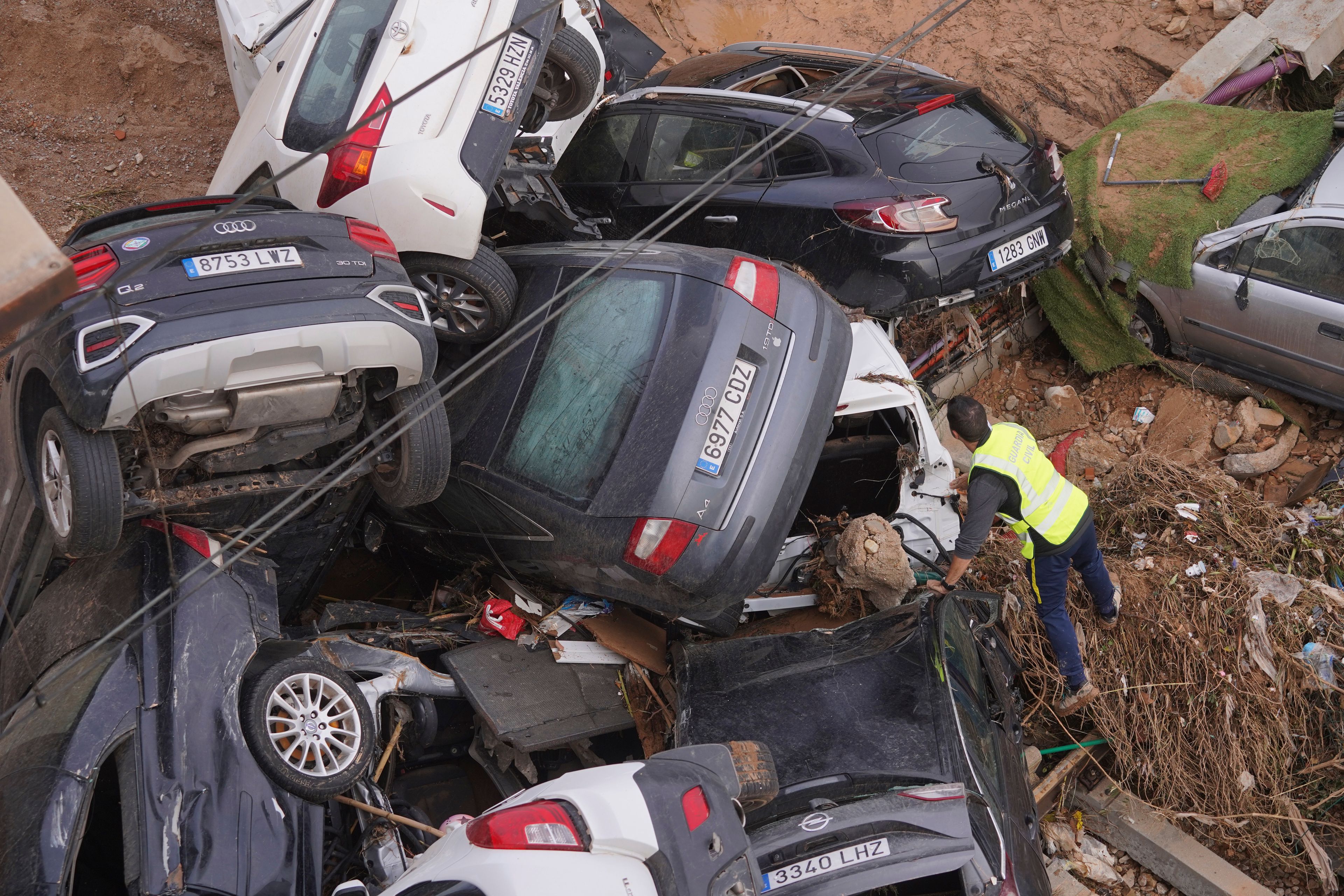 A civil guard searches for survivors in cars piled up on the outskirts of Valencia, Spain, Friday, Nov. 1, 2024 after flooding. (AP Photo/Alberto Saiz)