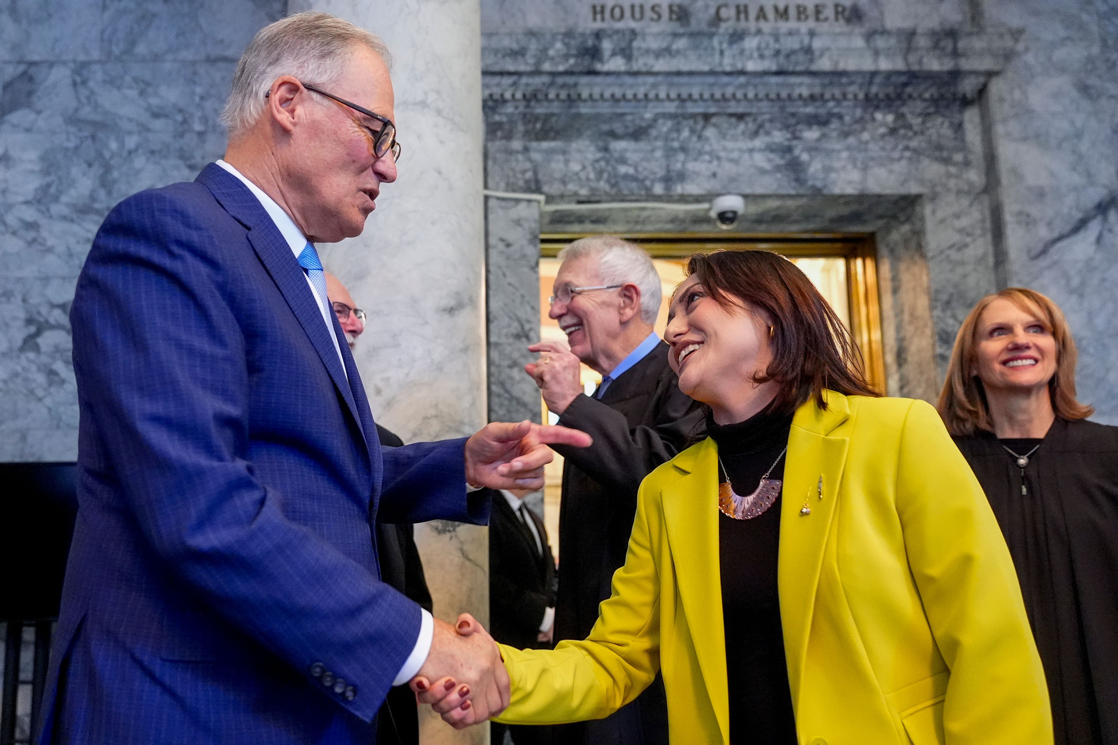 Washington Gov. Jay Inslee shakes hands with Sen. Yasmin Trudeau, D-Tacoma, after he delivered his annual State of the State address on the second day of the legislative session at the Washington state Capitol, Tuesday, Jan. 9, 2024, in Olympia, Wash. (AP Photo/Lindsey Wasson)