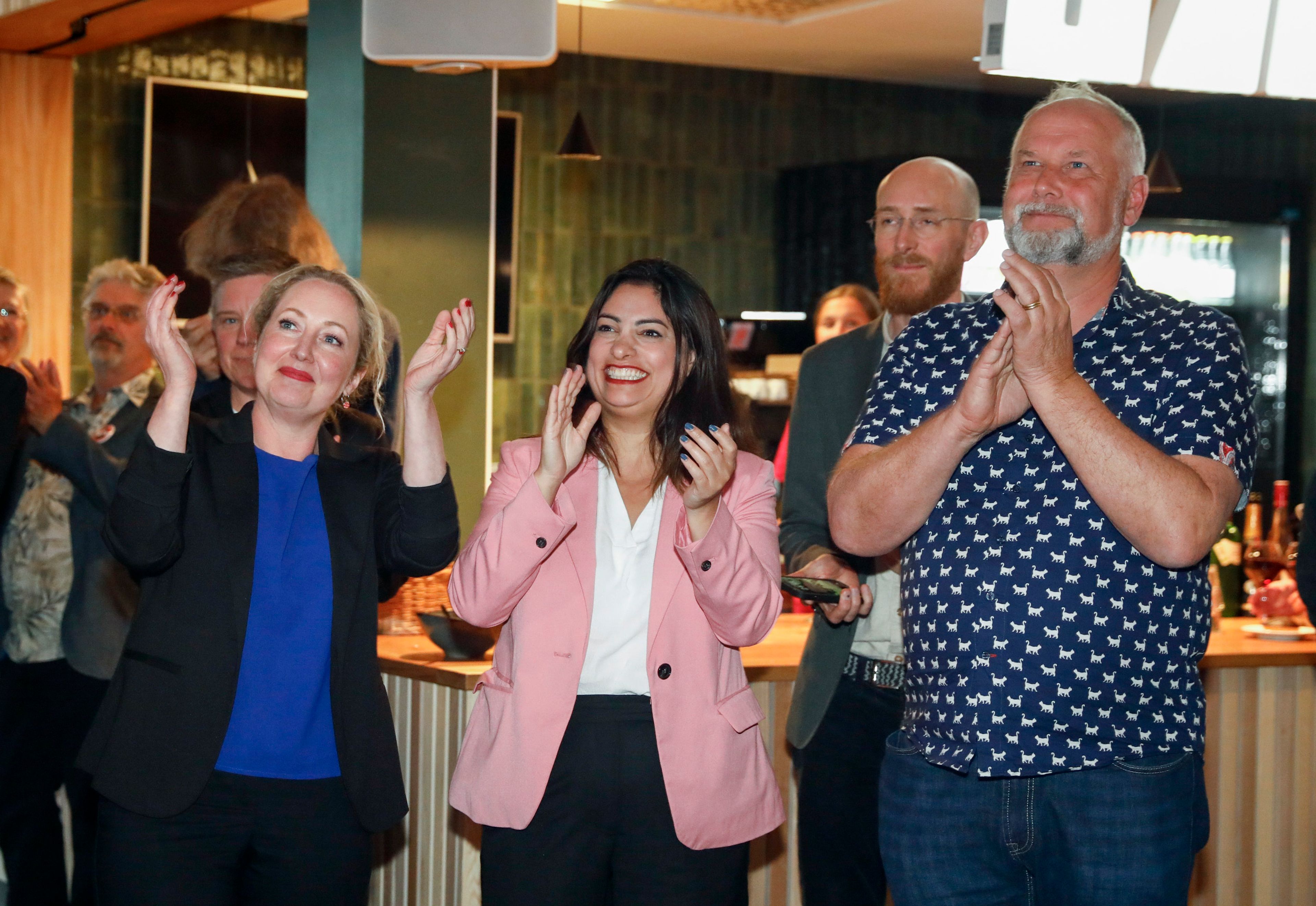 From left to right, the Left Party's top candidate for the EU elections, Hanna Gedin; party leader Nooshi Dadgostar and the Left Party's top candidate for the EU elections Jonas Sjöstedt clap at the party's election watch at Restaurang Bygden at Bildmuseet in Umeå, Sweden.