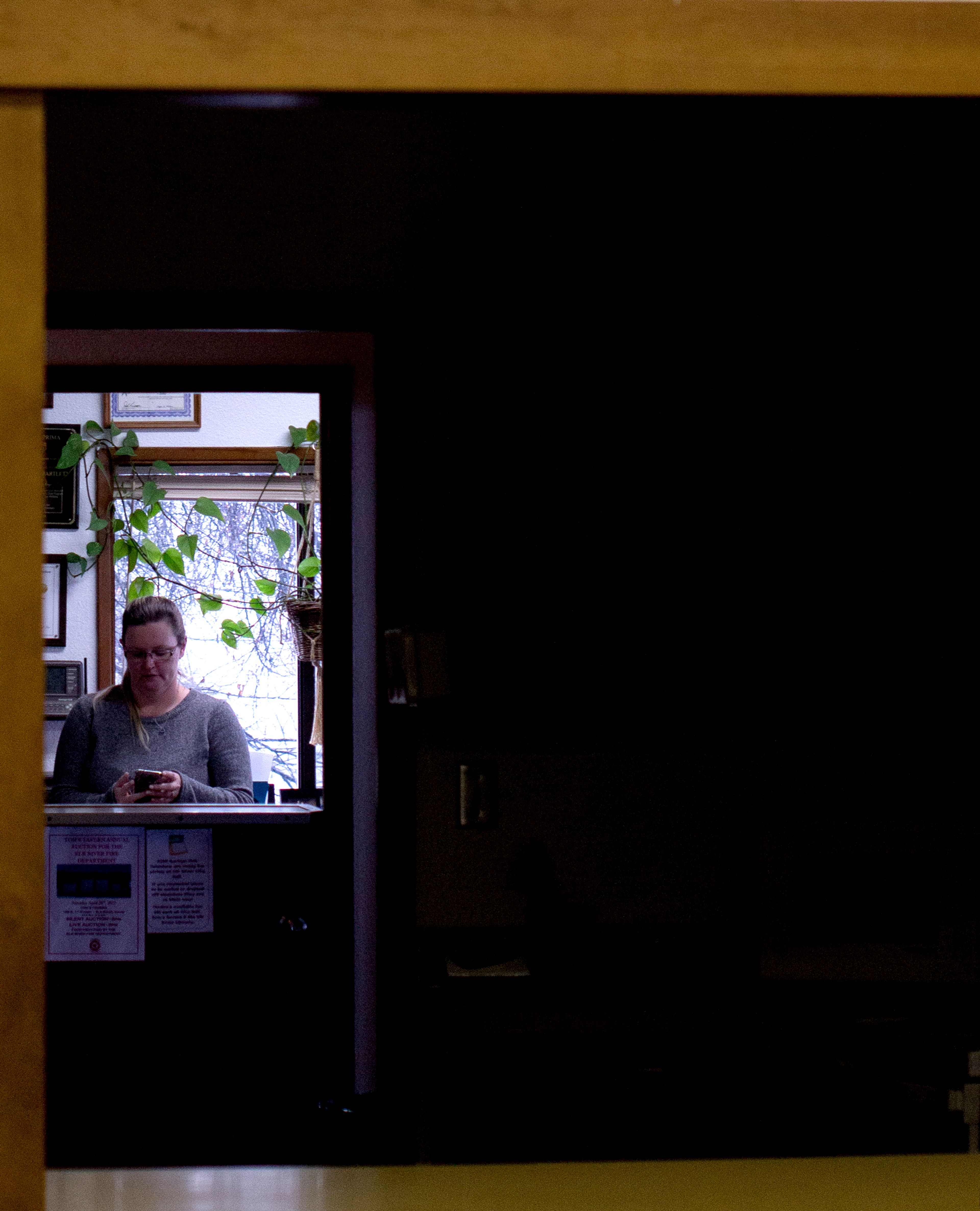 City Hall clerk, Christina Bartlett, checks a message on a rainy Monday morning in Elk River.