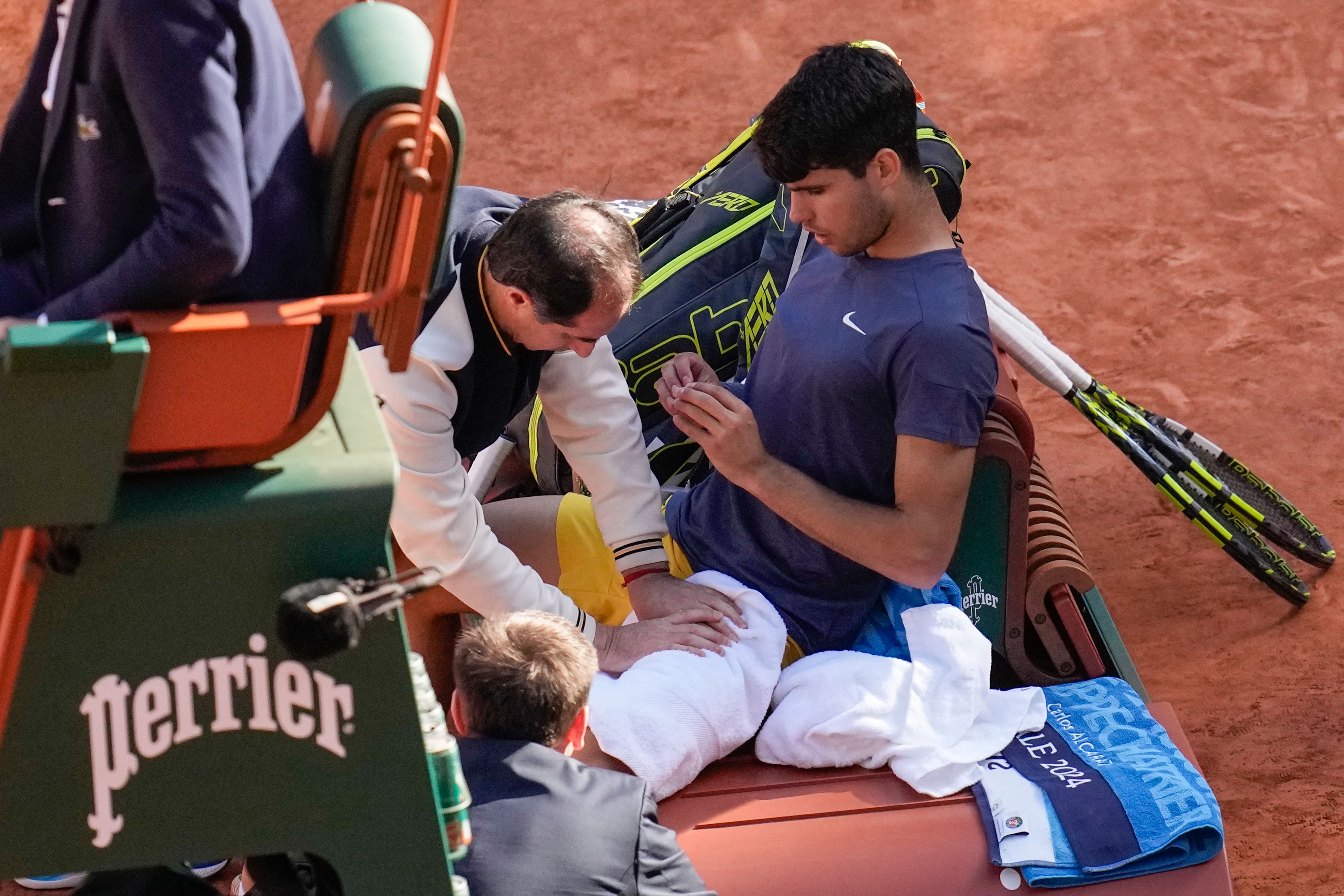 Spain's Carlos Alcaraz receives medical assistance in the men's final against Germany's Alexander Zverev at the French Open tennis tournament at the Roland Garros stadium in Paris, France, Sunday, June 9, 2024.