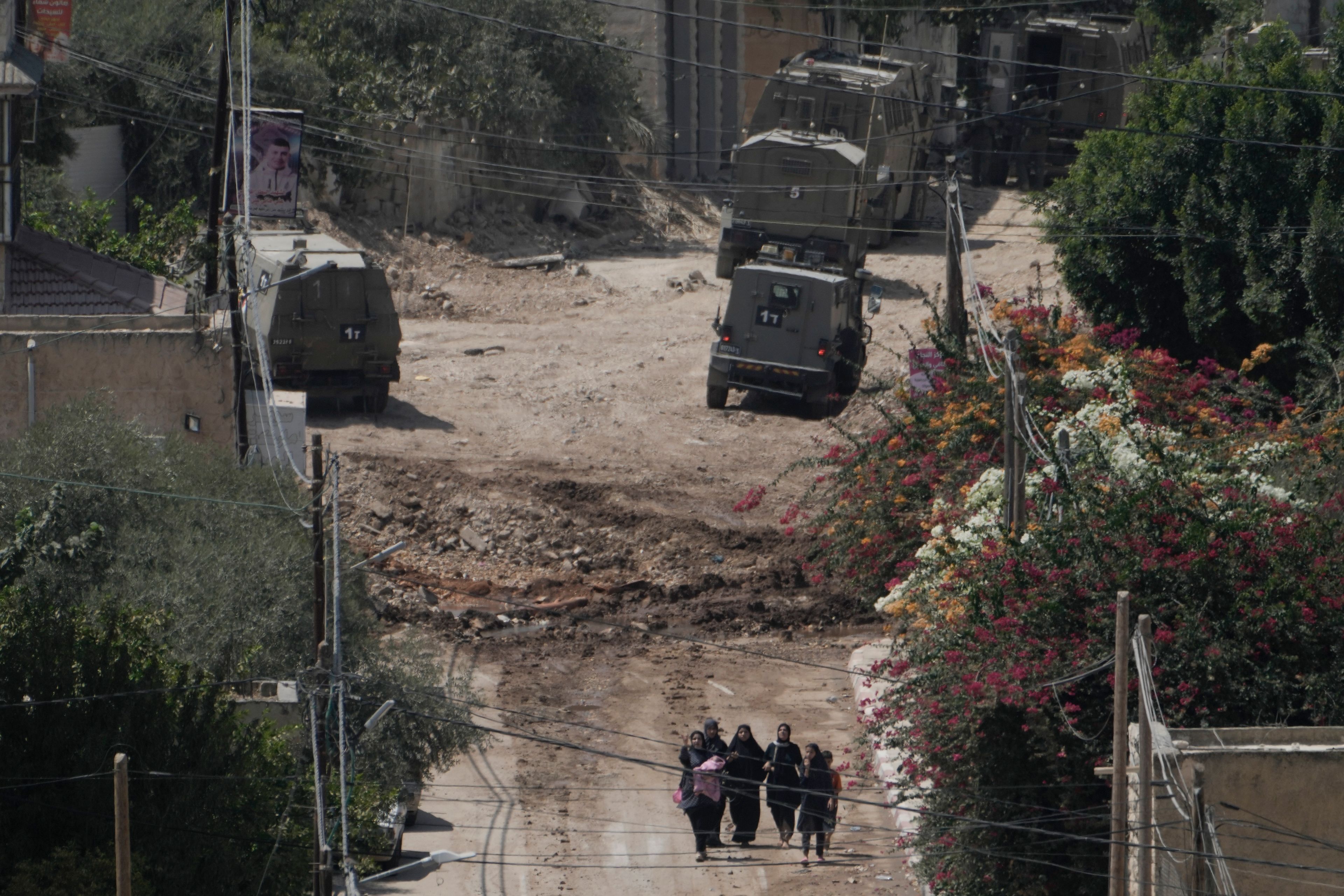 Palestinians walk down a street as they leave the West Bank Jenin refugee camp during an Israeli military operation, Saturday, Aug. 31, 2024. (AP Photo/Majdi Mohammed)