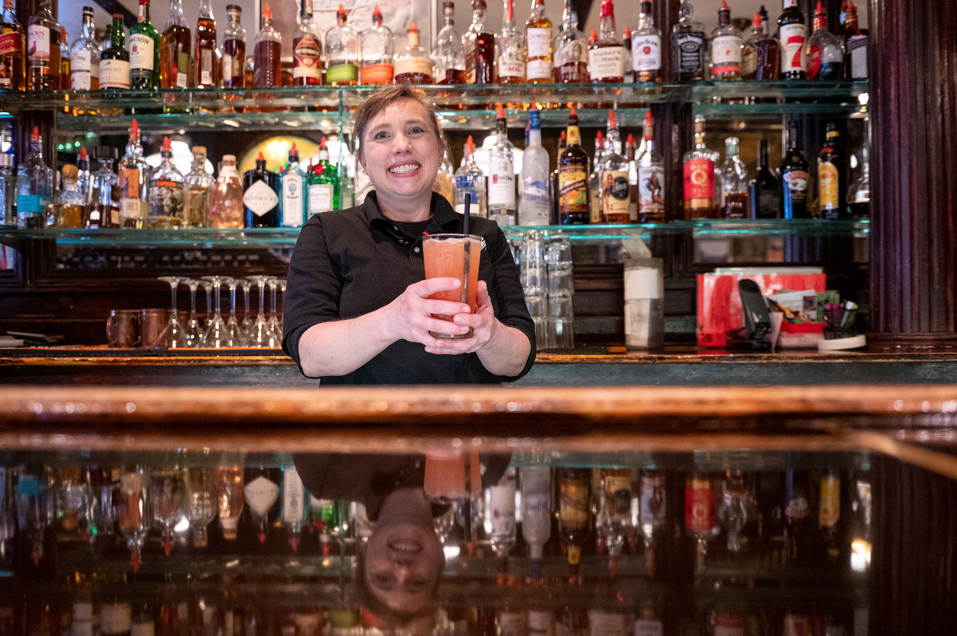 Owner Tawny Szumlas poses with a “Pippy” cocktail behind the counter of Rico’s Public House in Pullman.