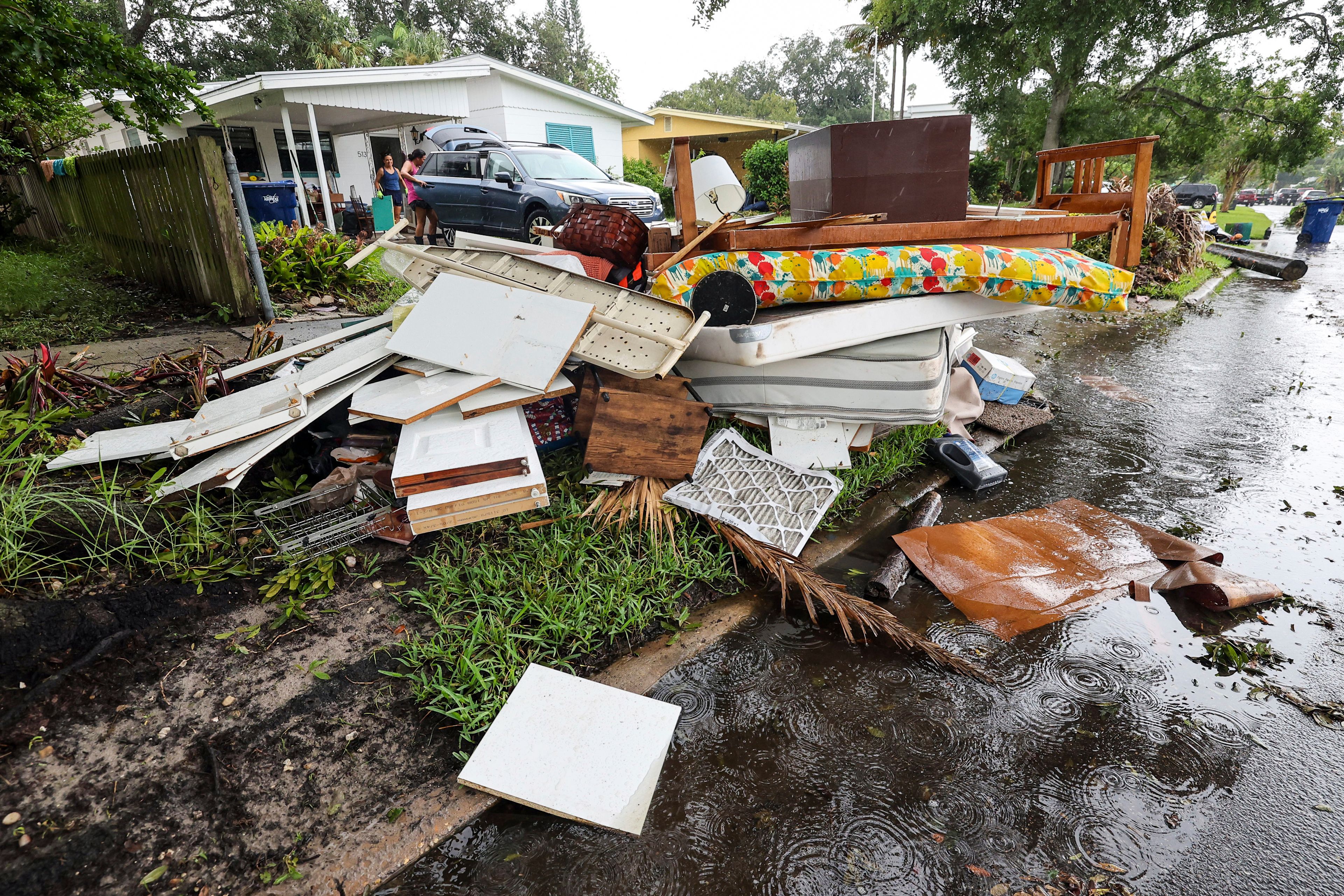 Residents clean contents of their home after flooding from Hurricane Helene on Davis Island Saturday, Sept. 28, 2024, in Tampa, Fla. (AP Photo/Mike Carlson)