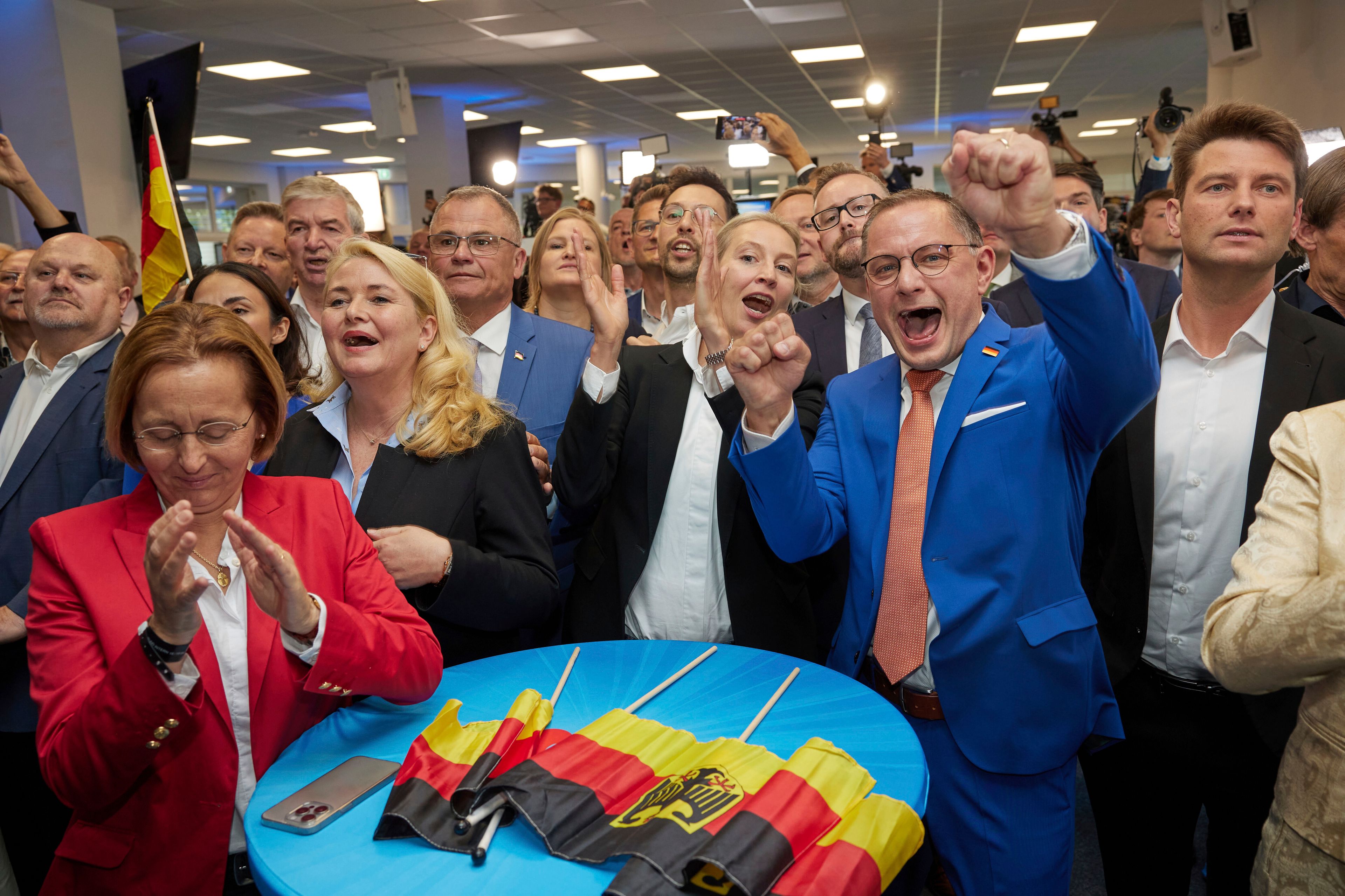 Alice Weidel, center, and Tino Chrupalla, center rught, both AfD federal chairmen, cheer at the AfD party headquarters during the forecast for the European elections, in Berlin, Sunday June 9, 2024.