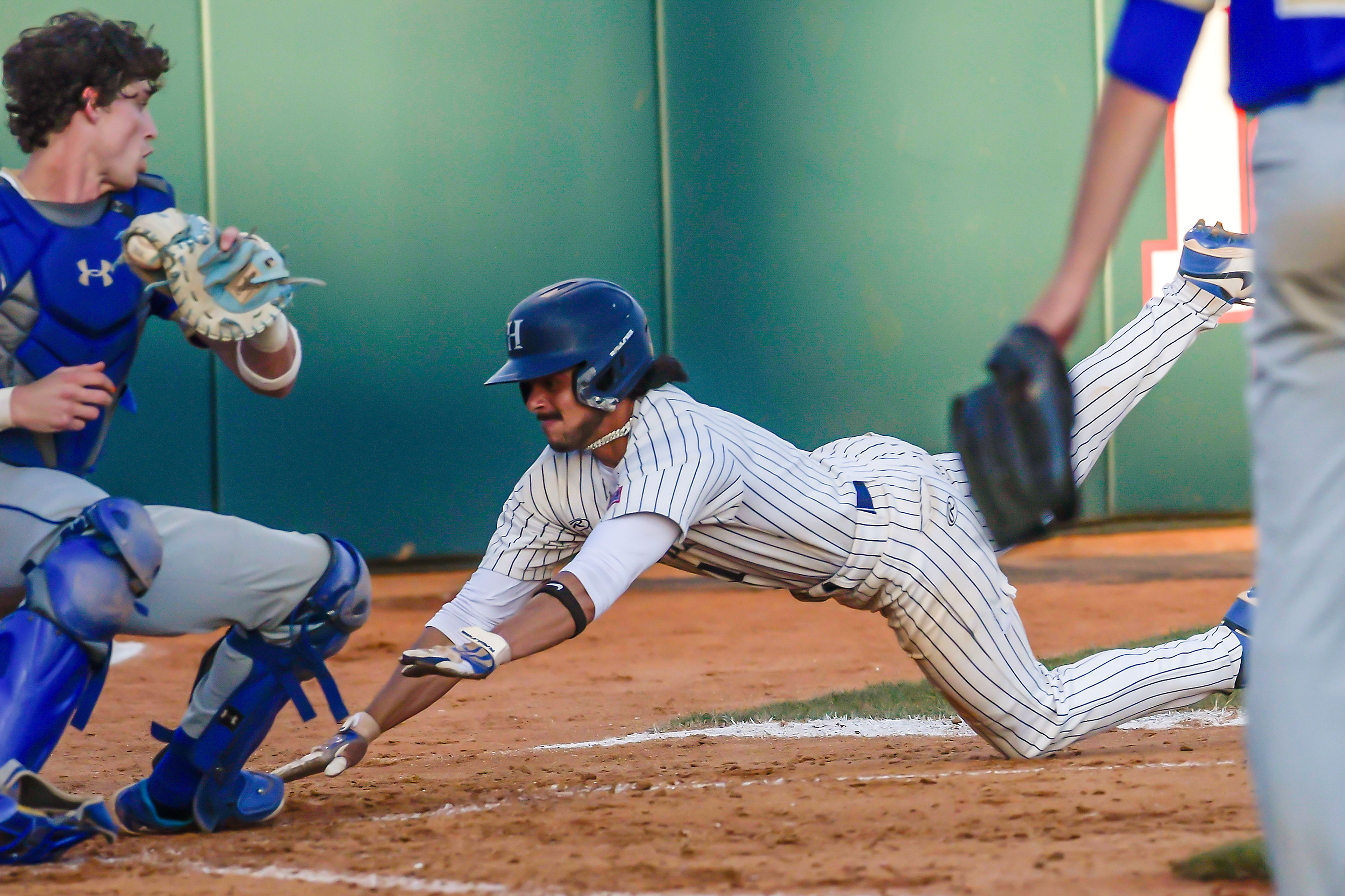 Hope International’s David Rivera goes into a dive to score against Tennessee Wesleyan in Game 19 of the NAIA World Series at Harris Field Friday in Lewiston.