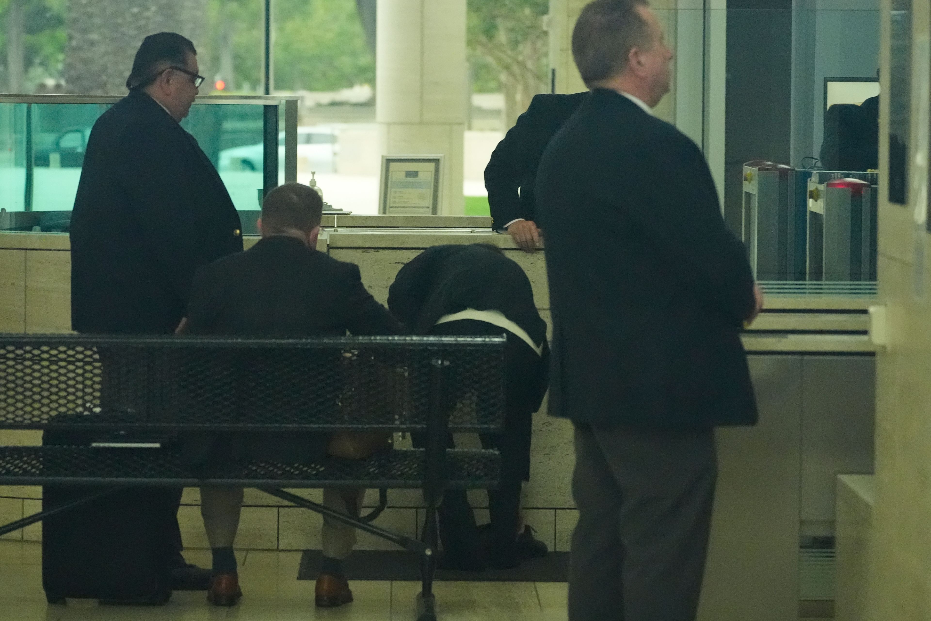 Ippei Mizuhara, center, the former longtime interpreter for the Los Angeles Dodgers baseball star Shohei Ohtani, removes his shoes to go through security at federal court, Tuesday, June 4, 2024, in Los Angeles. Mizuhara pleaded guilty to bank and tax fraud on Tuesday and admitted to stealing nearly $17 million from the Japanese baseball player to pay off sports betting debts.