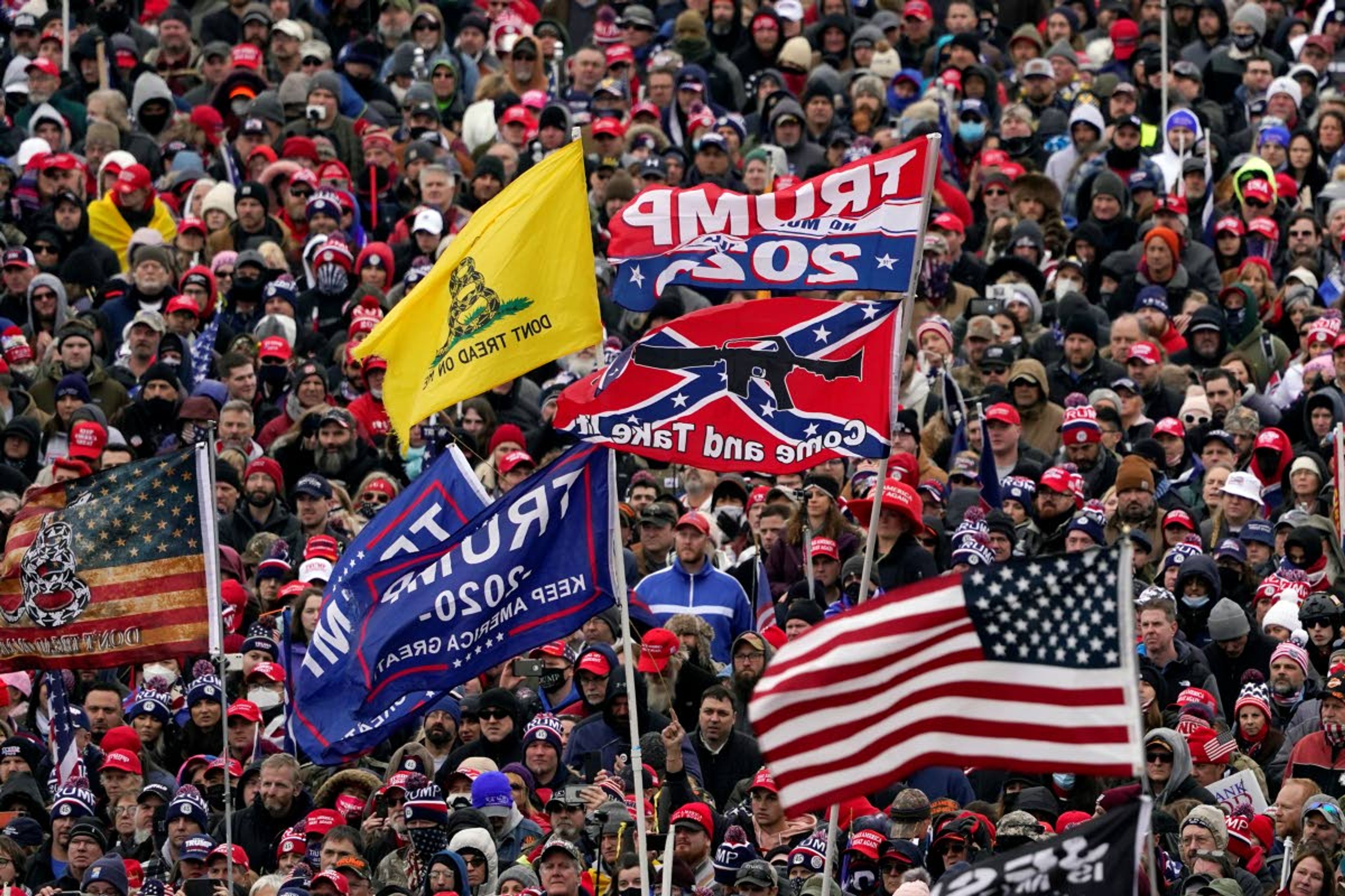 FILE In this Wednesday, Jan. 6, 2021, file photo, supporters listen as President Donald Trump speaks as a Confederate-themed and other flags flutter in the wind during a rally in Washington. War-like imagery has begun to take hold in mainstream Republican political circles in the wake of the deadly attack on the U.S. Capitol, with some elected officials and party leaders rejecting calls to tone down their rhetoric contemplating a second civil war. (AP Photo/Evan Vucci, File)