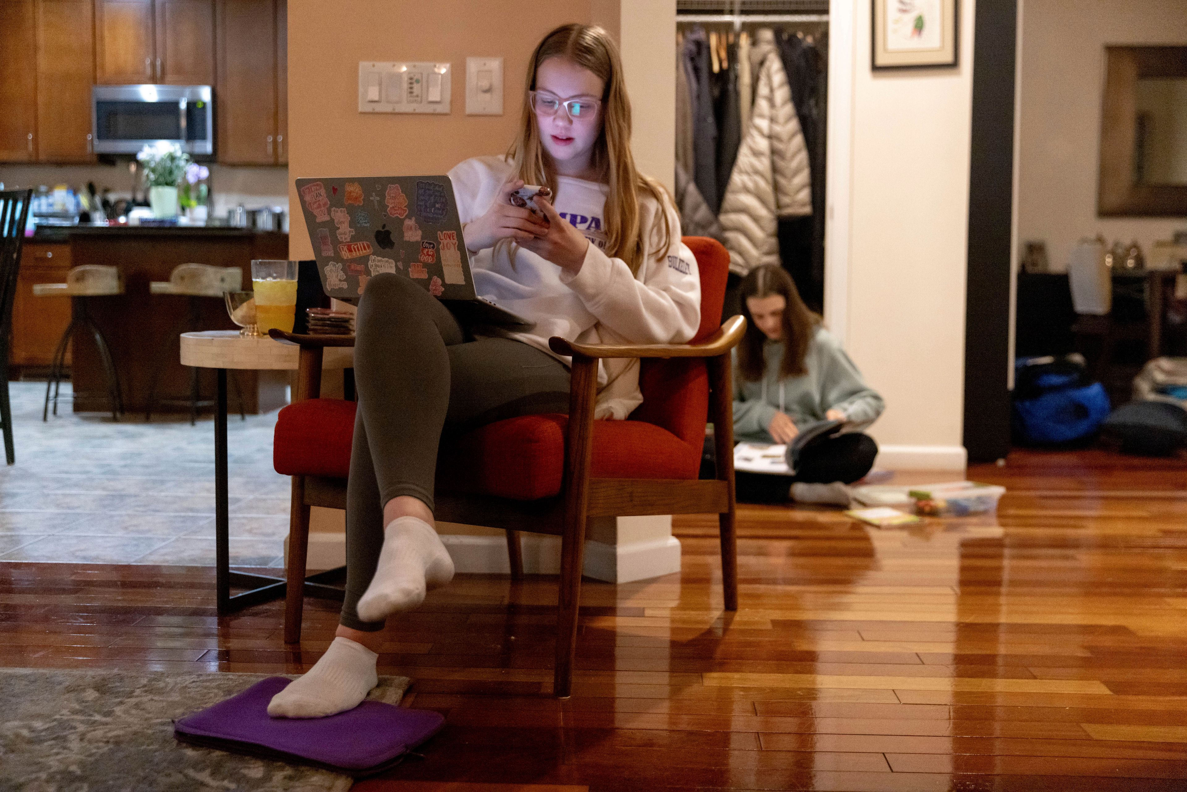 Kate Bulkeley uses her phone to print textbook pages while Sutton packs art materials ahead of a ski vacation, Friday, Feb. 16, 2024, in Westport, Conn. It is hard to be a teenager today without social media. For those trying to stay off social platforms at a time when most of their peers are immersed, the path can be challenging, isolating and at times liberating. It can also be life-changing.